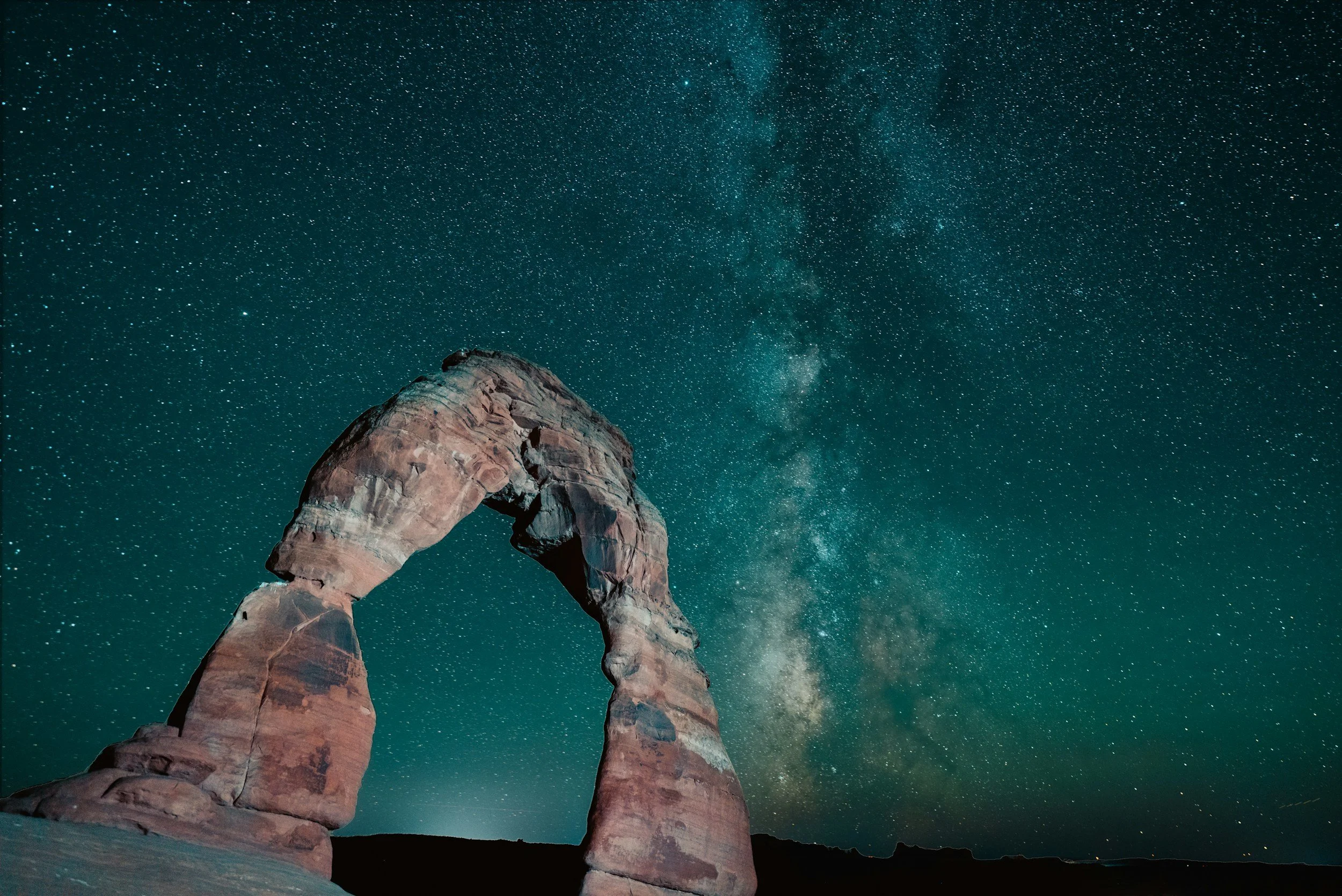Delicate Arch at night with stars behind