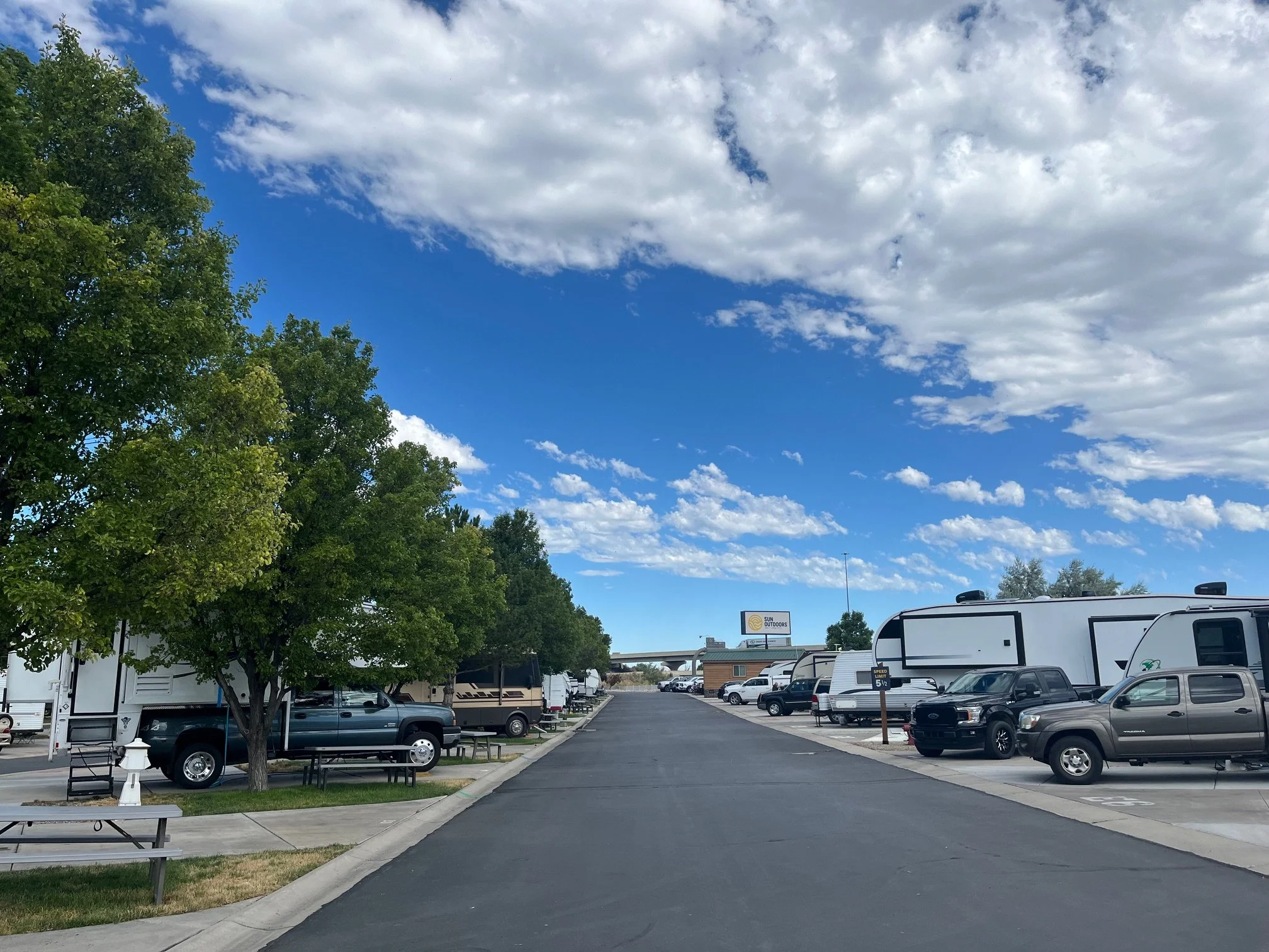 Rows of RVs under trees at Sun Outdoors Salt Lake City campground