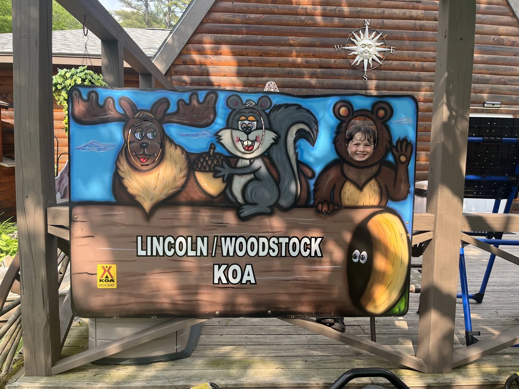 The author's son with his face in a cut out wooden sign for Lincoln Woodstock KOA