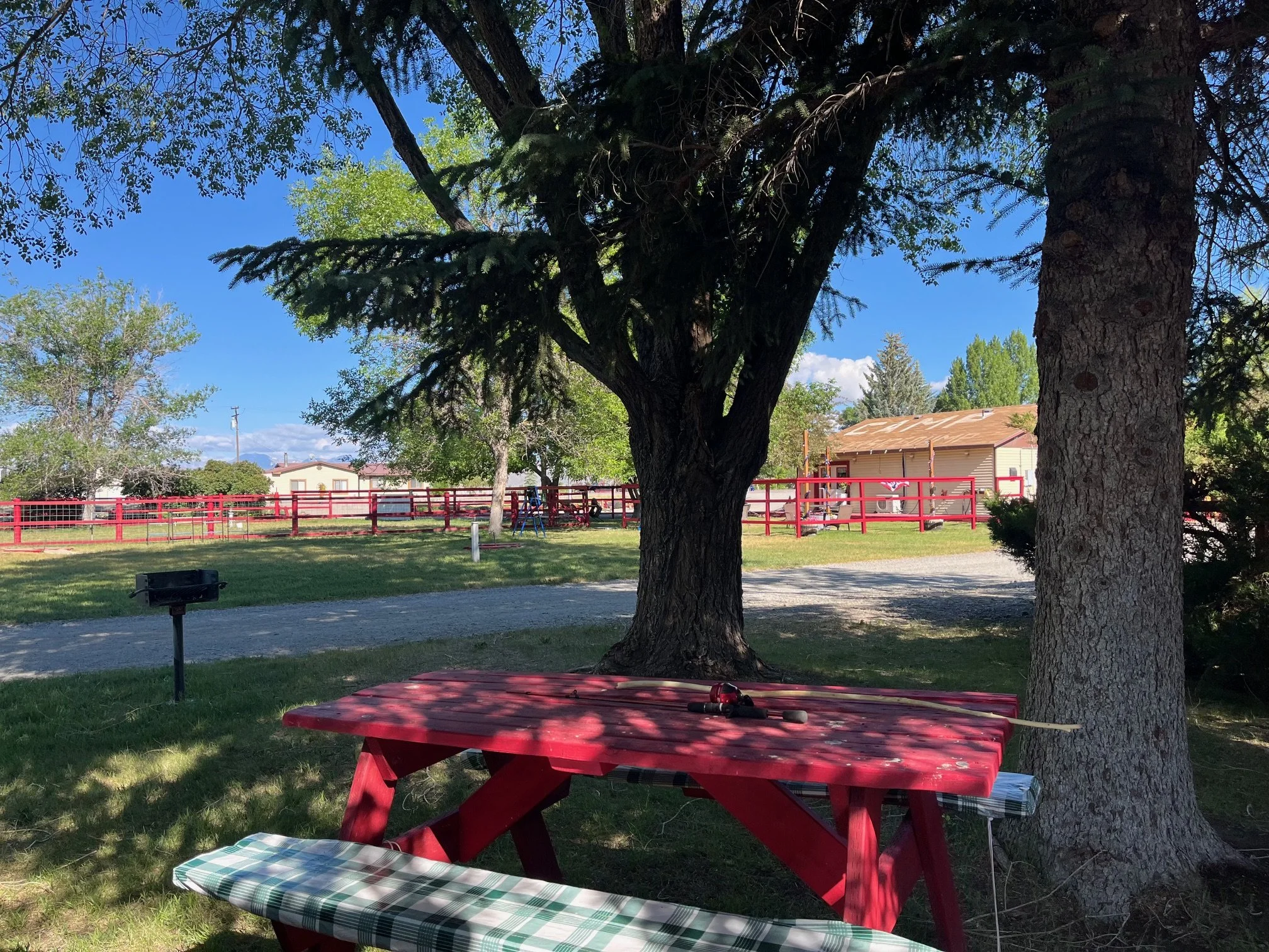 Bright red picnic table with fishing pole and long stick on top