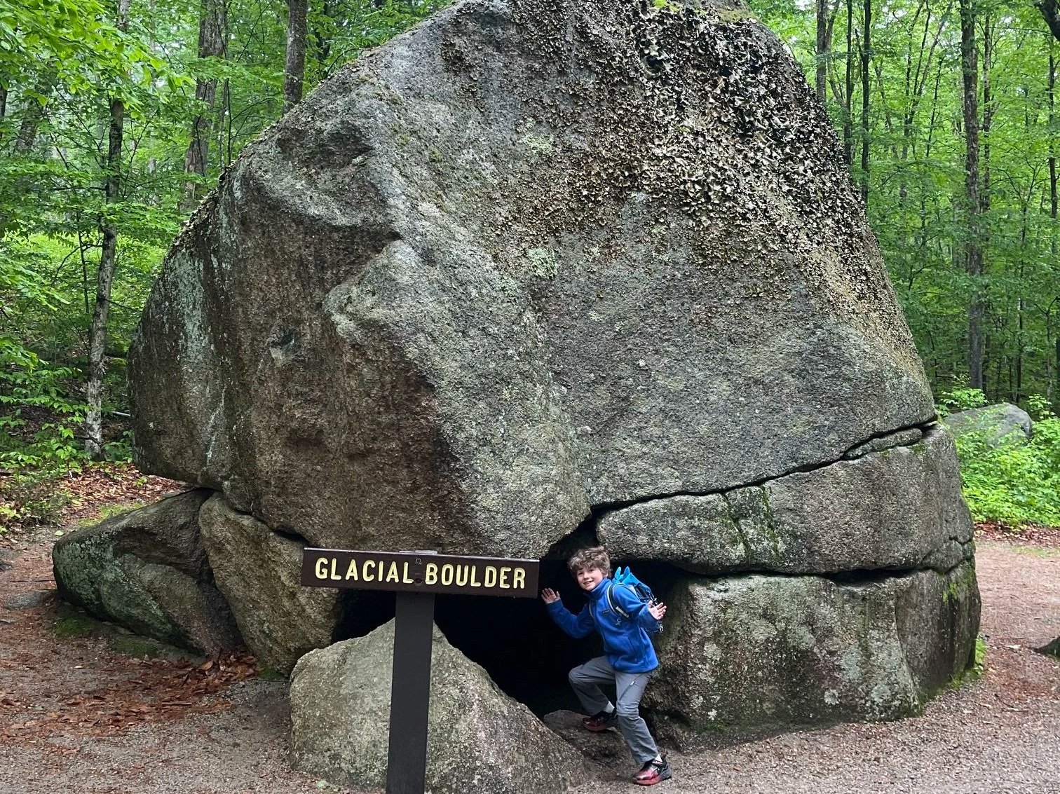 The author's son next to one of the glacial boulders near the start of the Flume Gorge trail