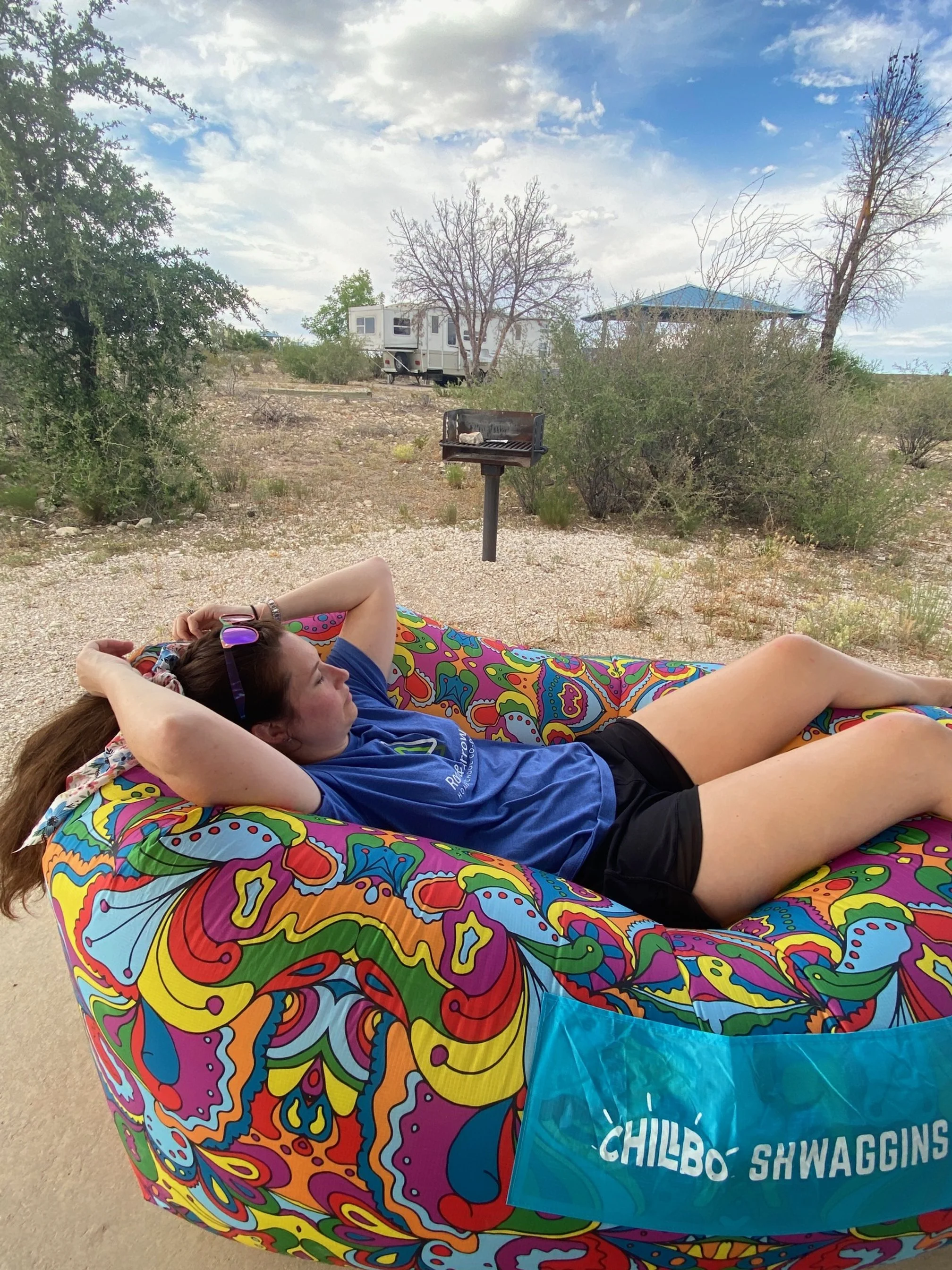 The author sitting on a colorful inflatable chair at their Brantley Lake campground