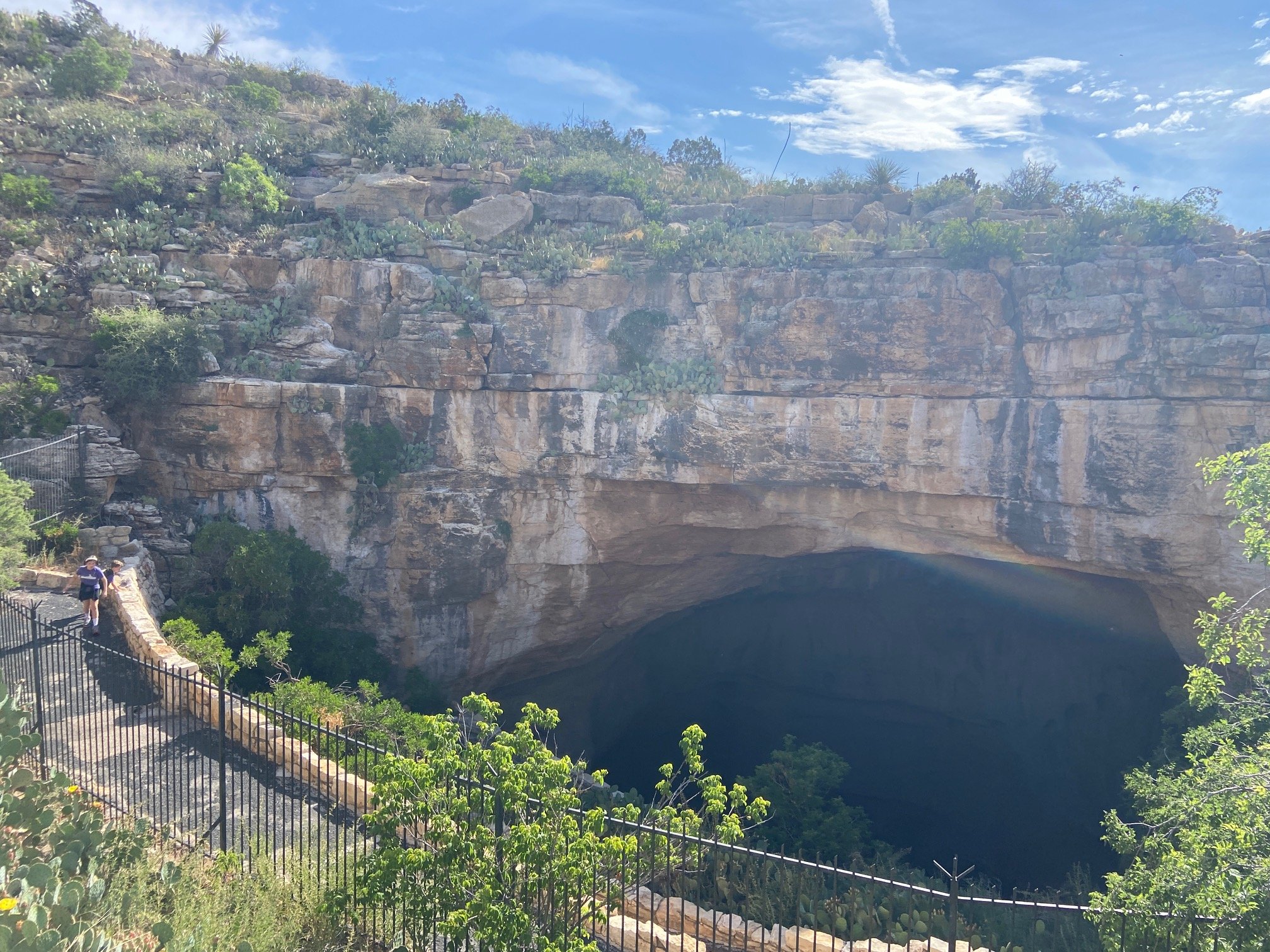 The author's children walk down the paved pathway into the entrance of the cave