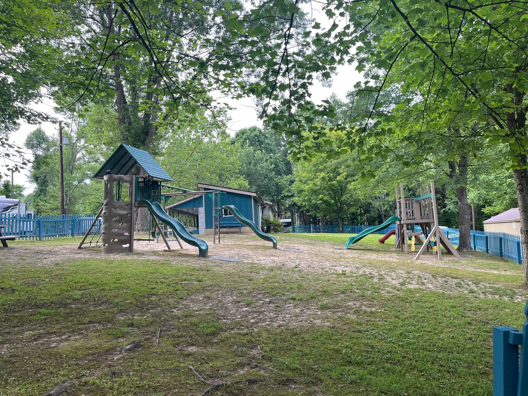 playground equipment at campground with blue fence around it