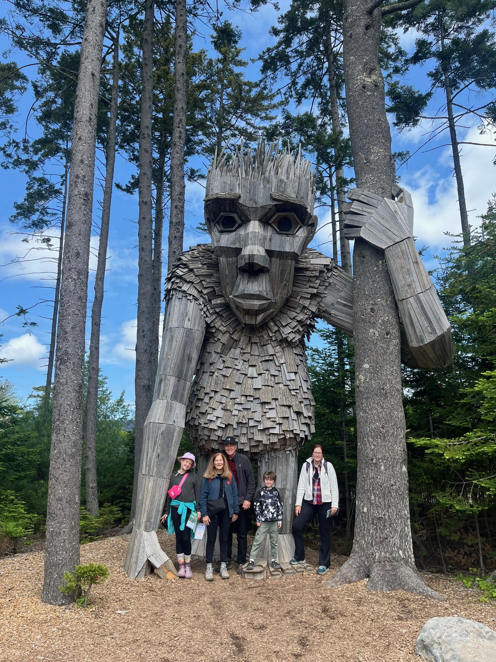 My family standing with one of the Thomas Dambo trolls in Coastal Maine Botanical Gardens