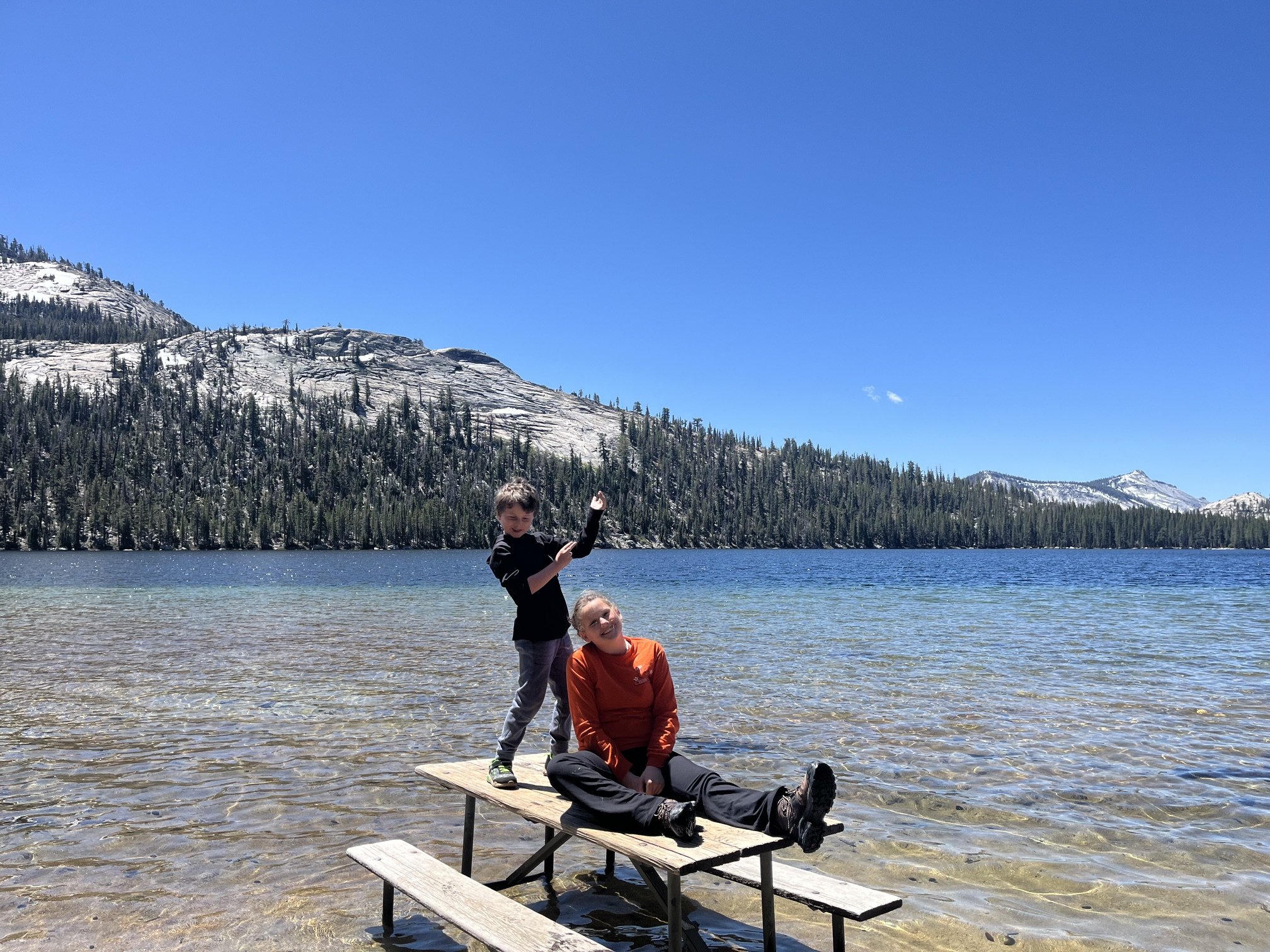 The author's children hanging out on a picnic table that's been put in the shallows of Tenaya Lake