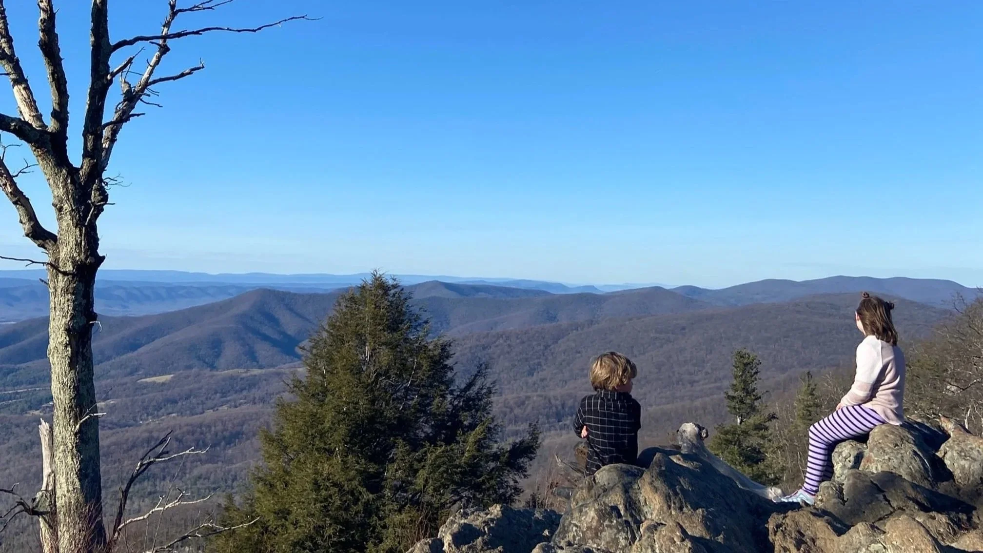The author's children sitting on rocks at a scenic overlook in Shenandoah National Park