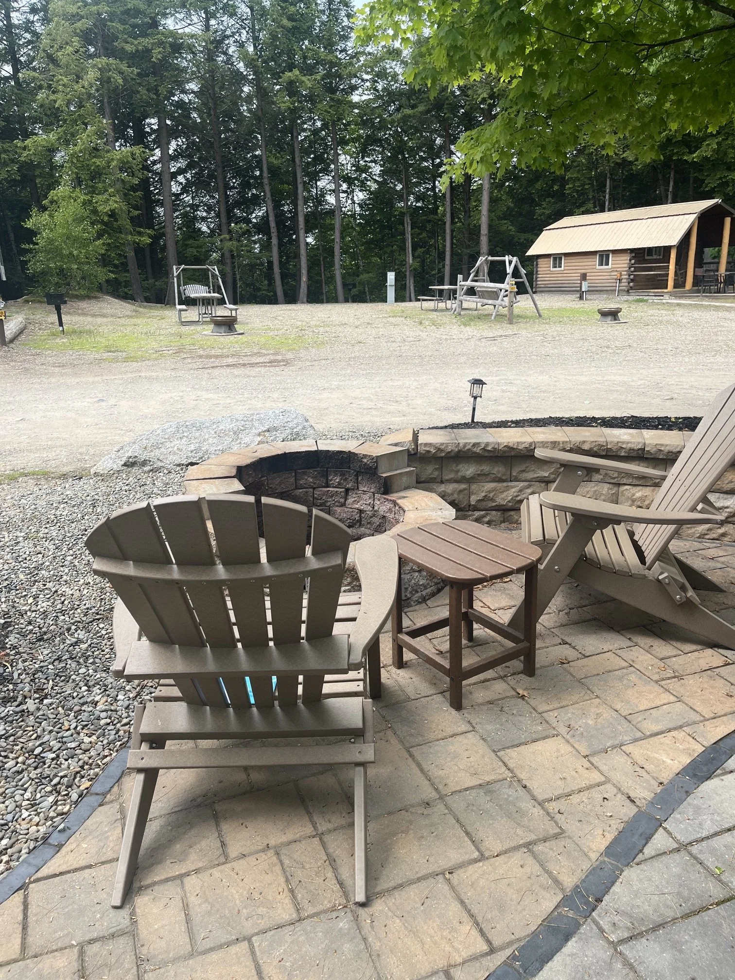Wooden Adirondack chairs next to a fire pit at the author's site
