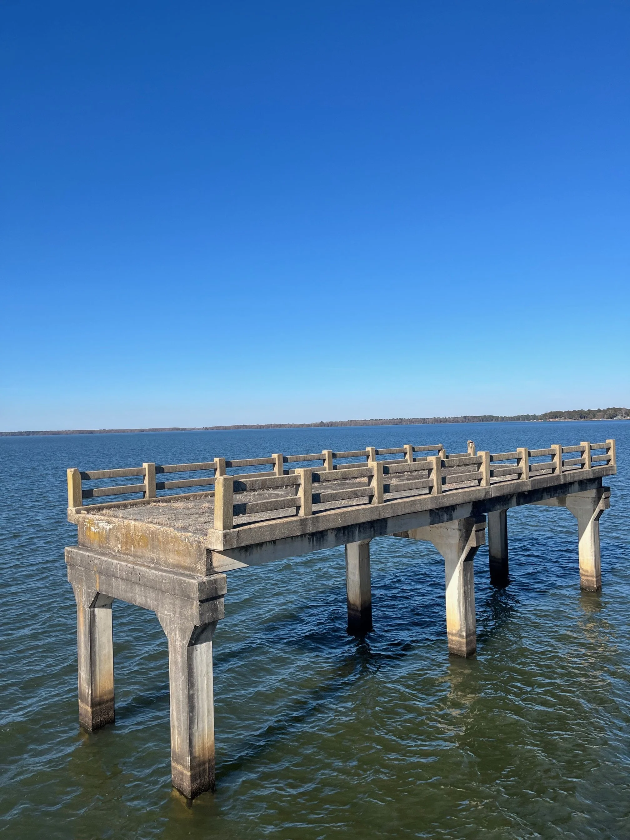 A large section of old bridge standing in the lake water
