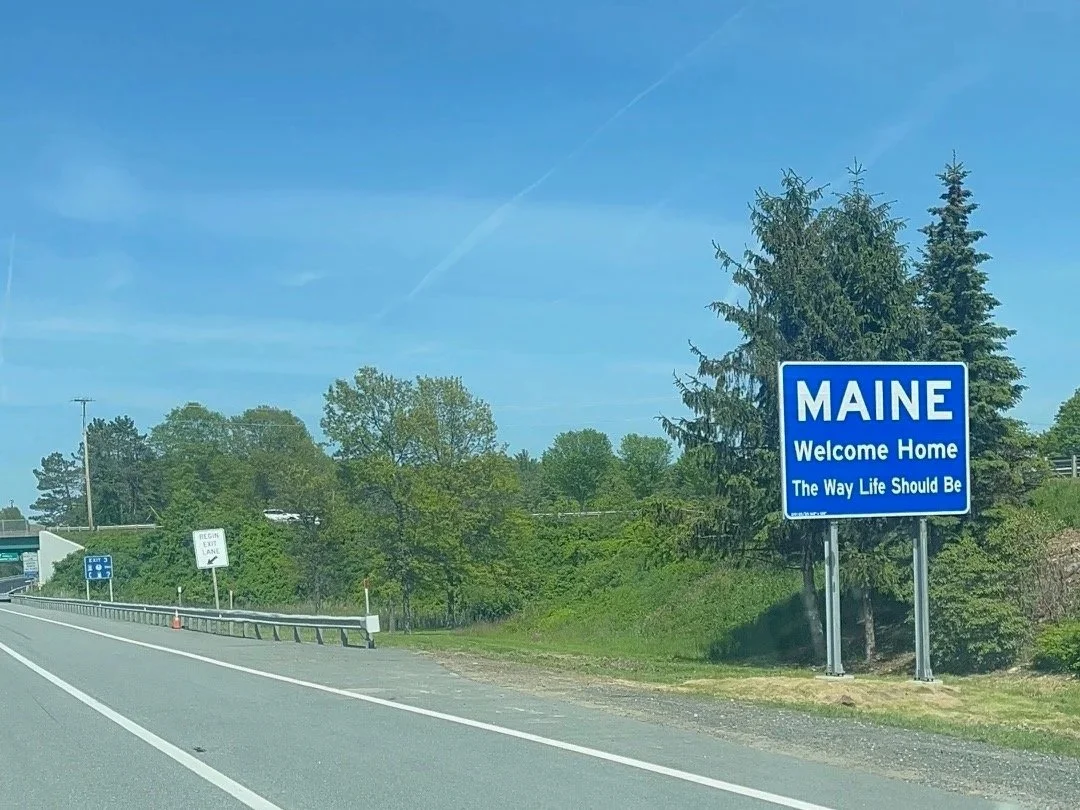 Blue welcome to Maine sign on the side of I-95