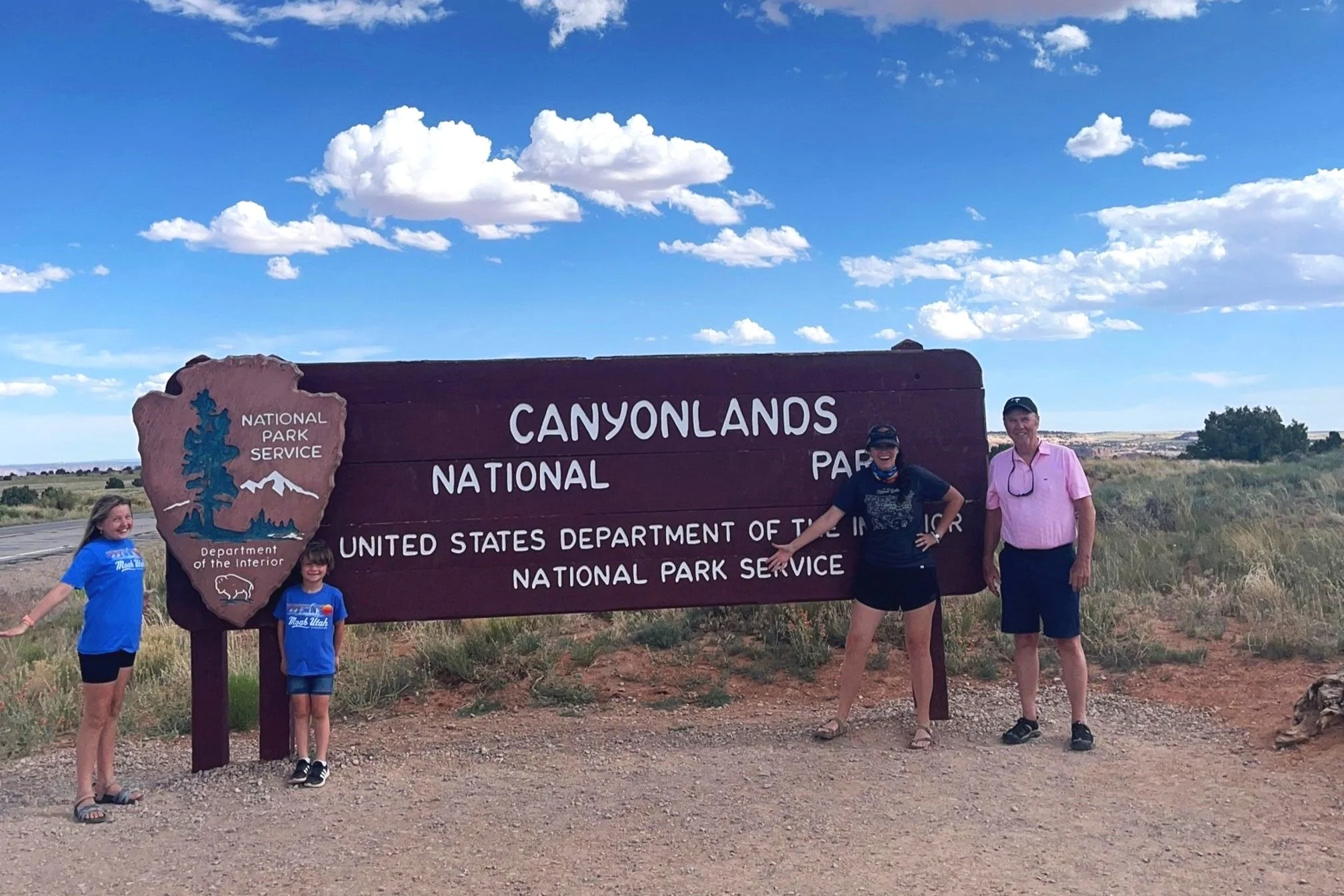 Entrance sign to Canyonlands National Park with the author and her family standing next to it