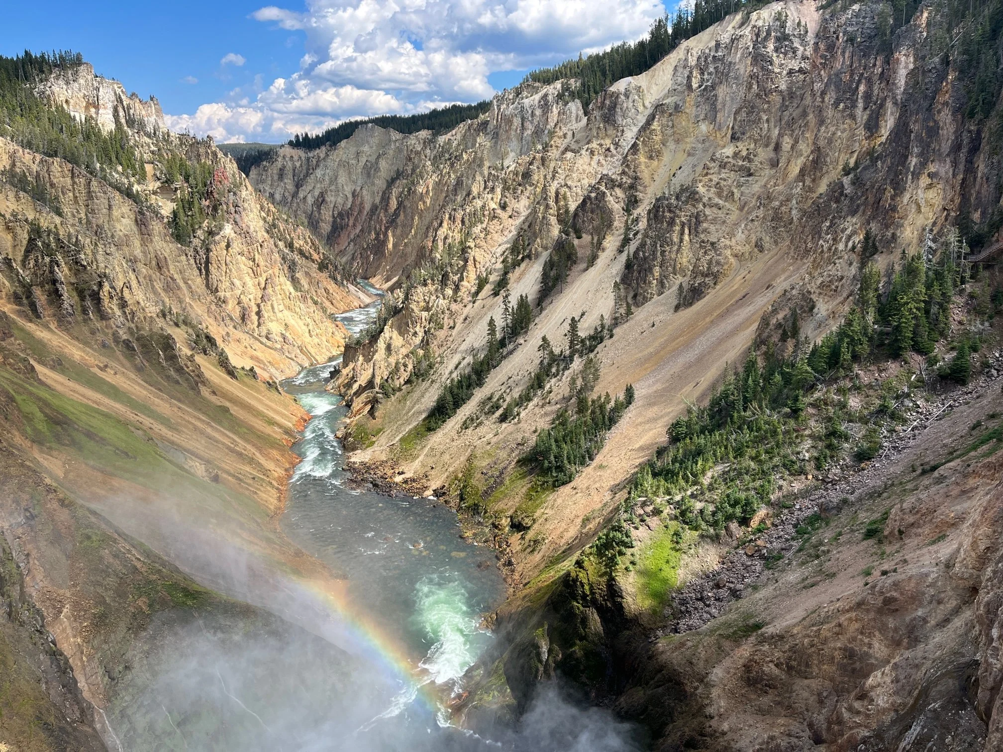 A rainbow appears in the spray from a waterfall in the Grand Canyon of the Yellowstone at Yellowstone National Park