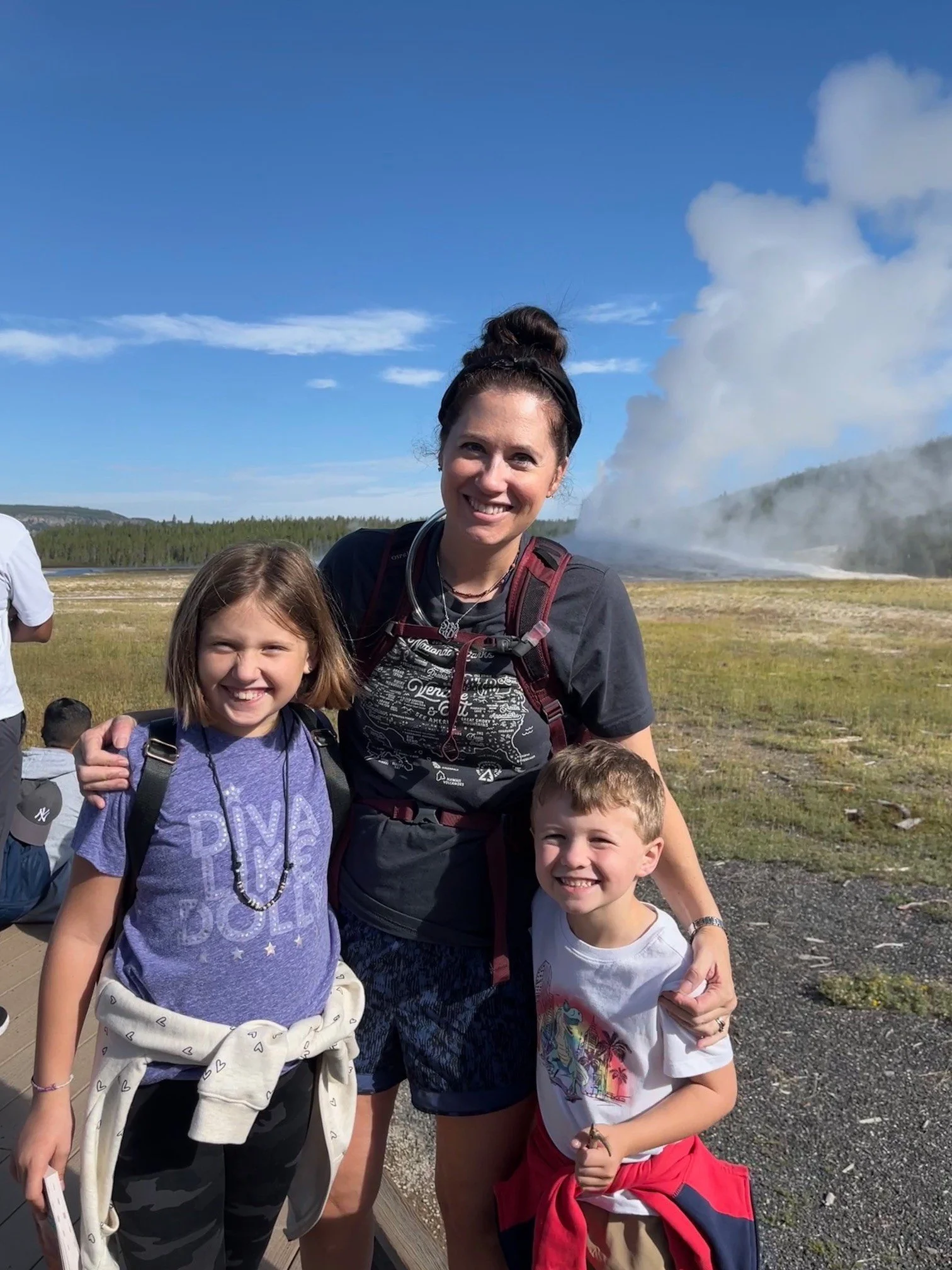 The author and her children on the boardwalk in front of Old Faithful