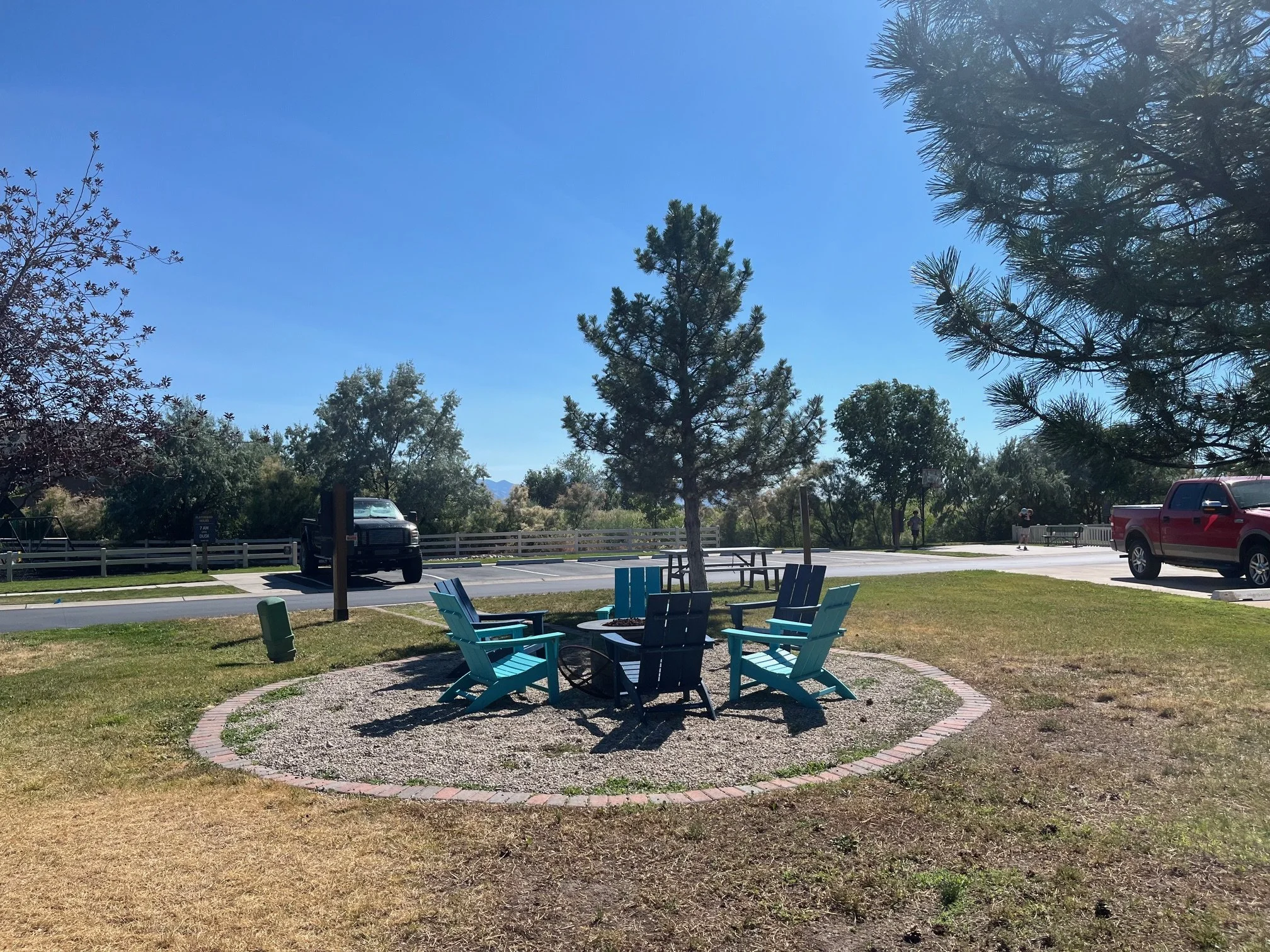 The community fire pit with teal and navy Adirondack chairs