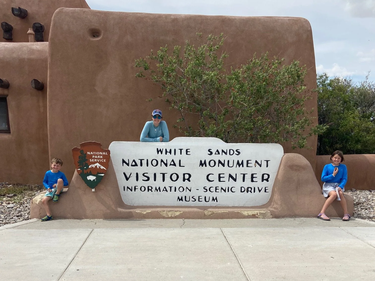 Entrance sign to White Sands National Park with the author and her kids