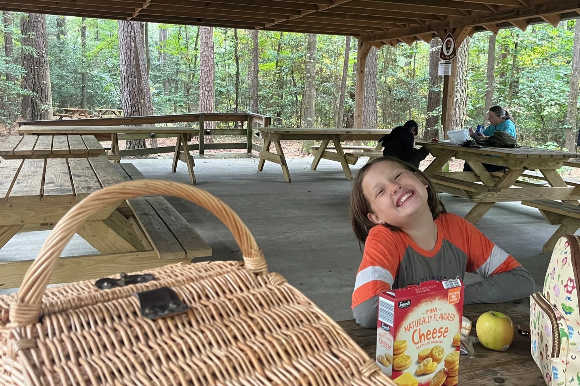 The author's daughter smiles while sitting at a picnic table in Congaree National Park