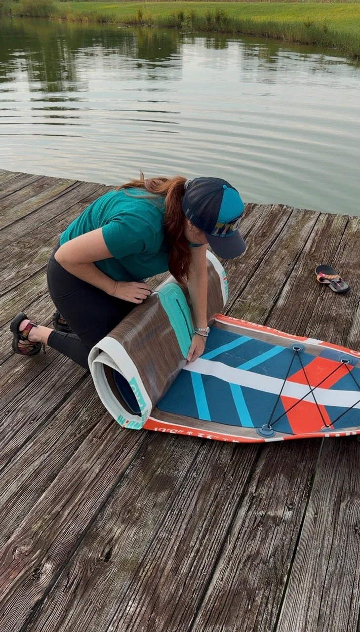 The author rolling up the Niphean paddle board to store in the carrying case