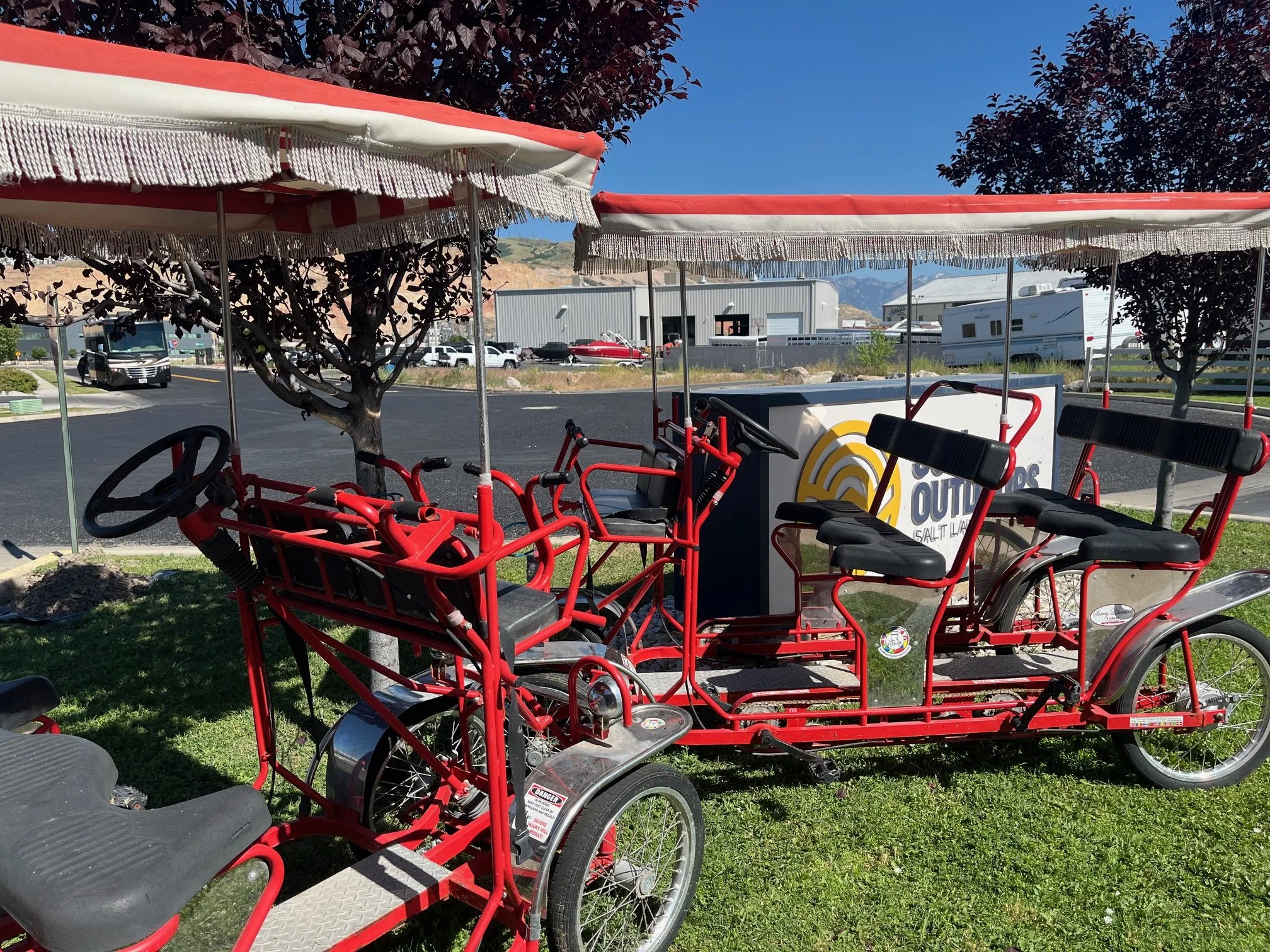 Bright red surreys with fringed covers parked near the Sun Outdoors Salt Lake City sign