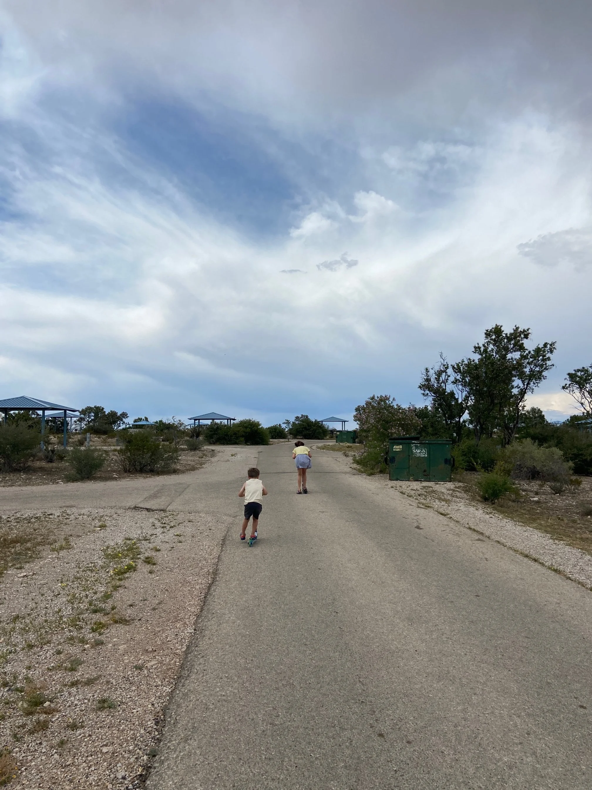 The author's children ride their scooters through the campground