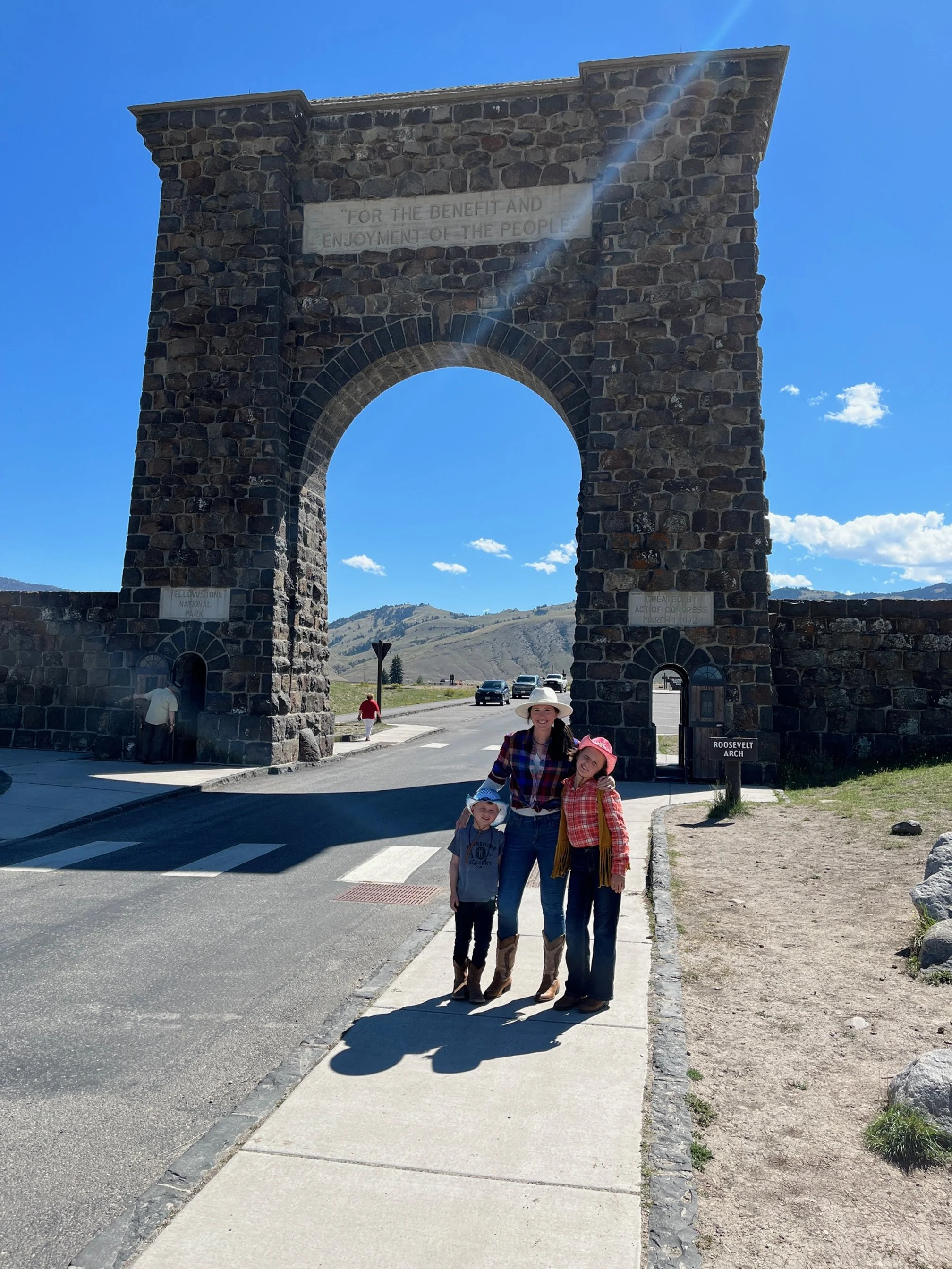 The author and her two children in front of the Roosevelt Arch