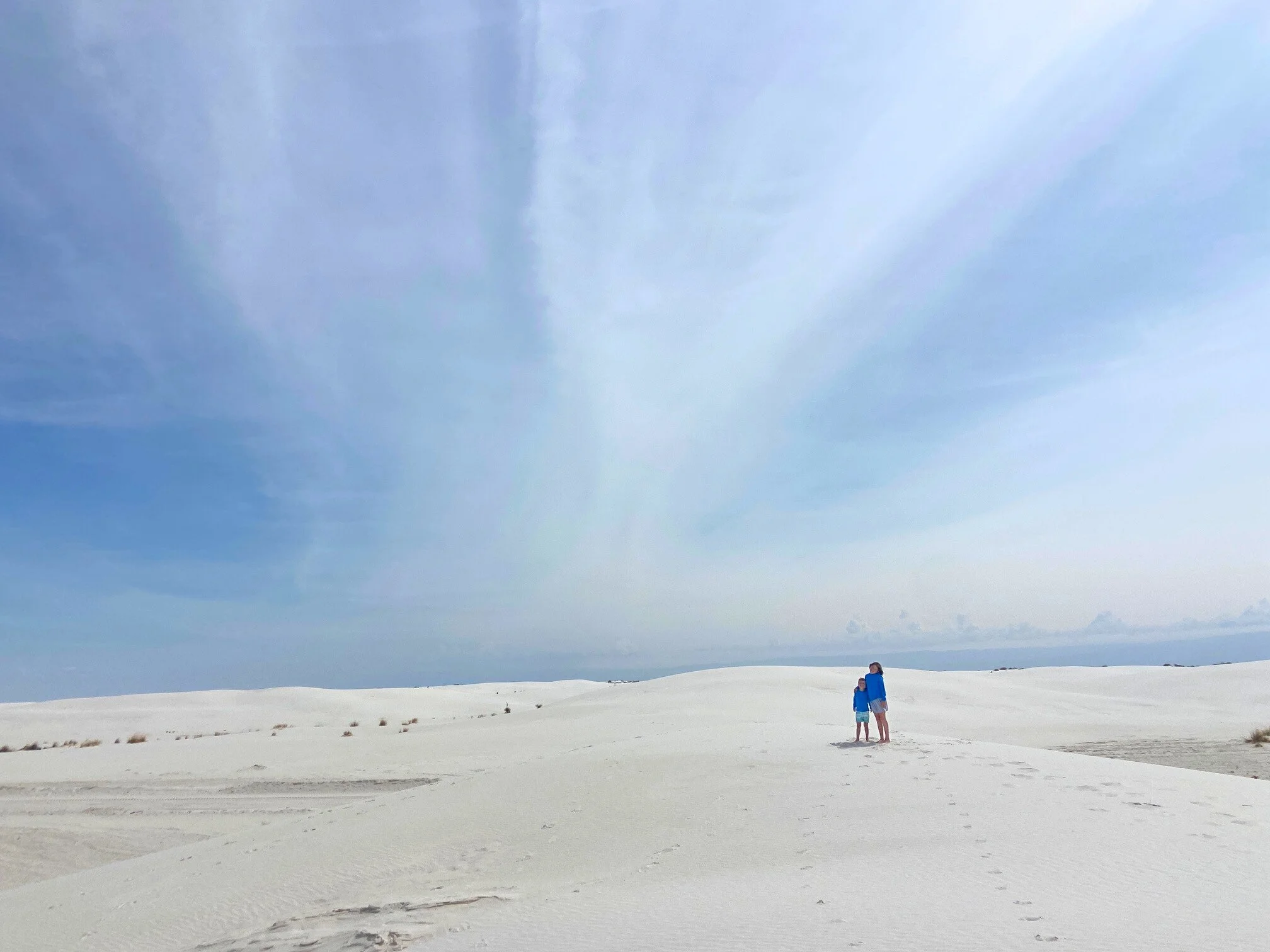 The author's children in hat and long sleeved shirts on the white dunes