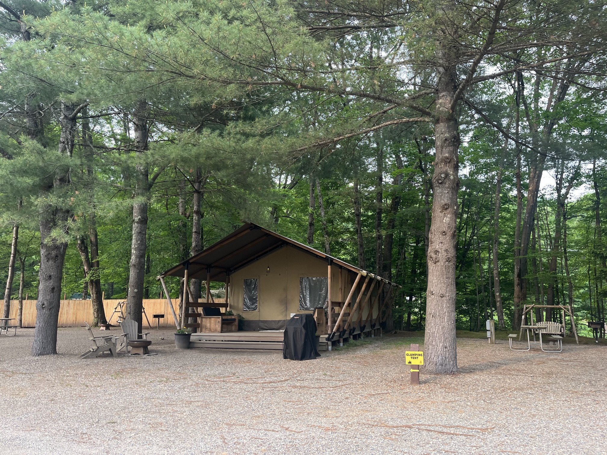 A safari-style glamping tent with grill and chairs