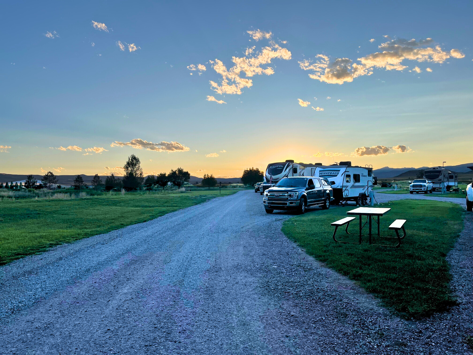 The author's camper parked at their site with the sunset in the distance