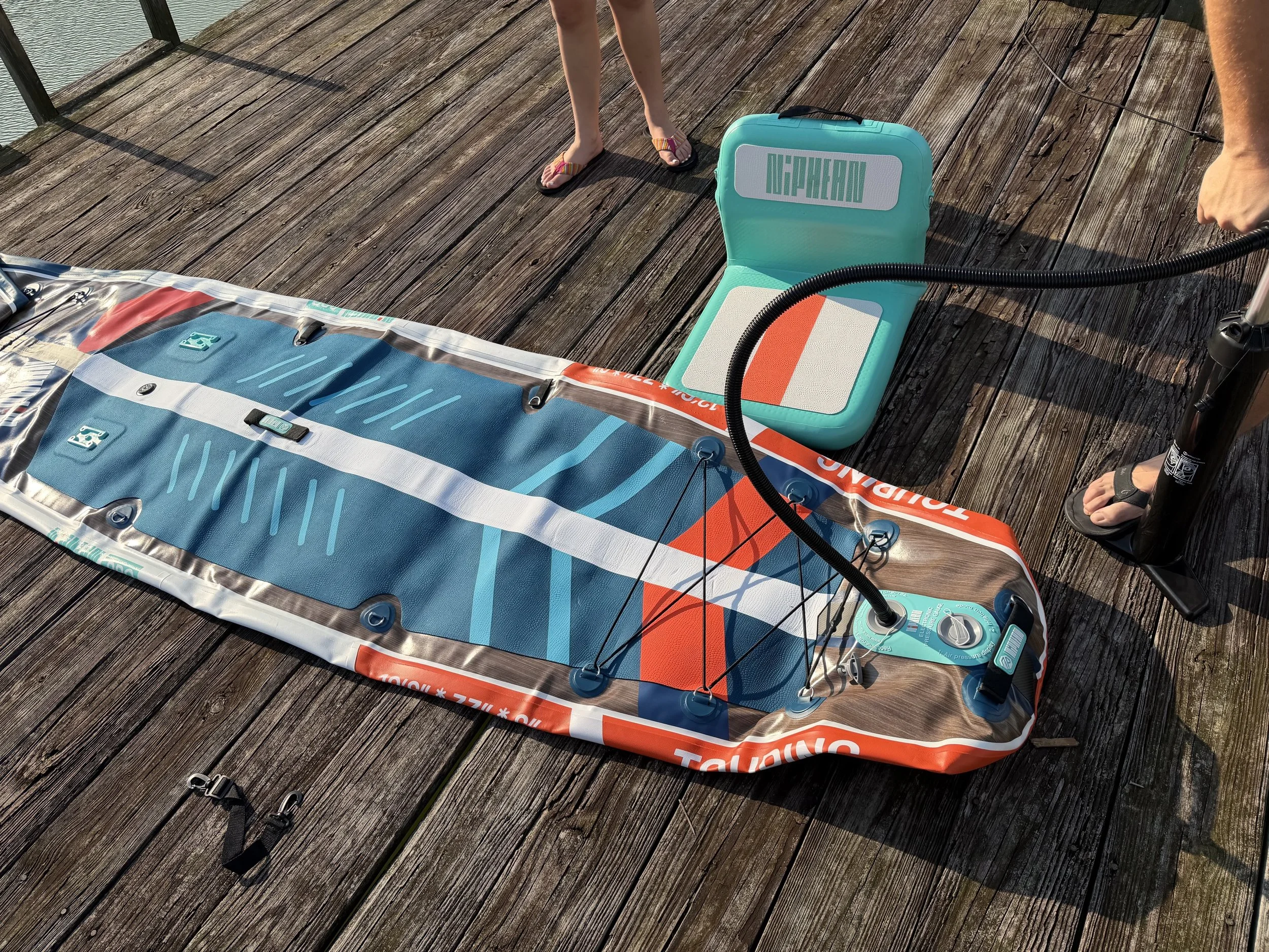The author's family inflates the paddle board on a wooden dock