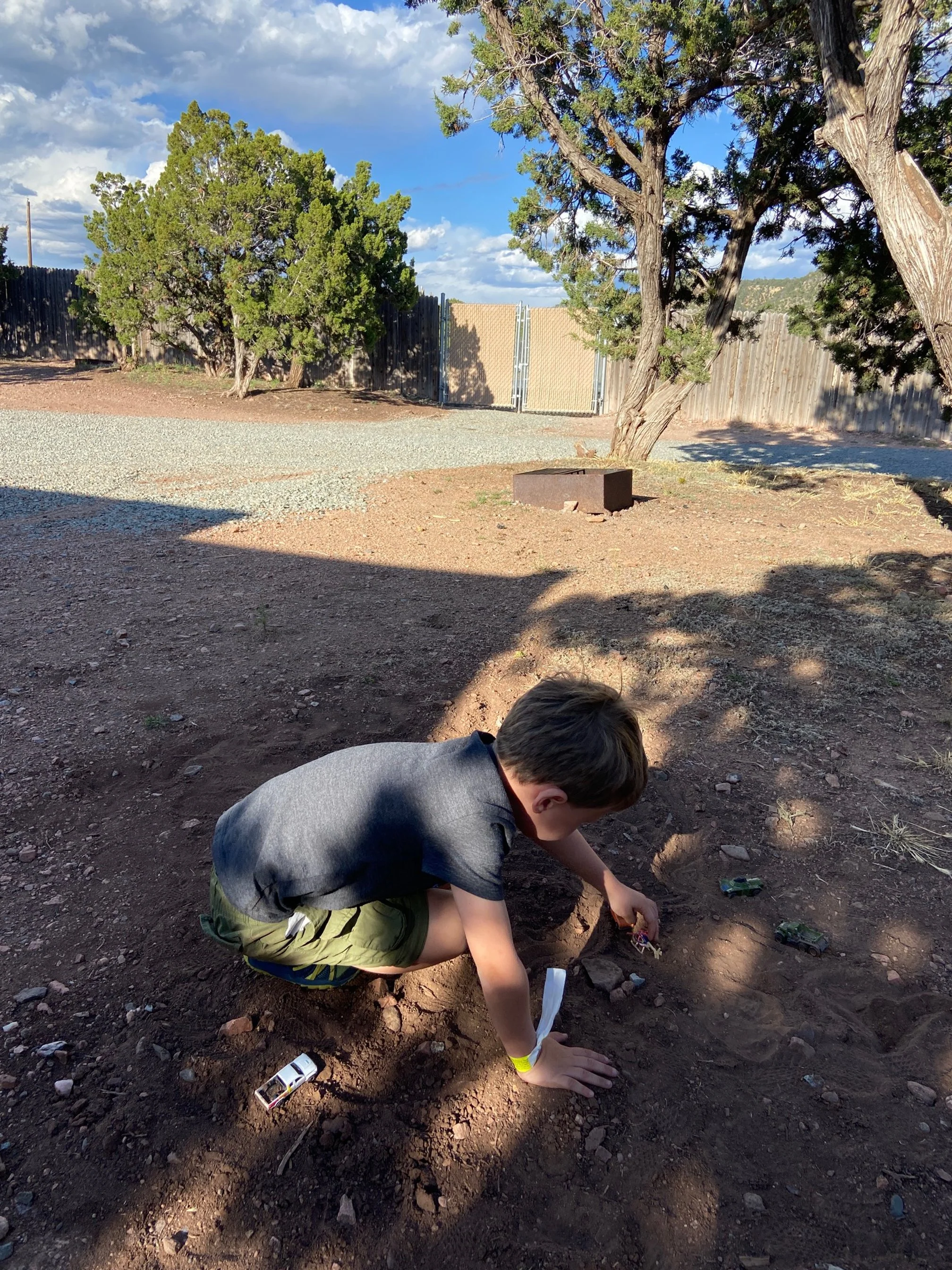 The author's son playing with toy cars at their campsite