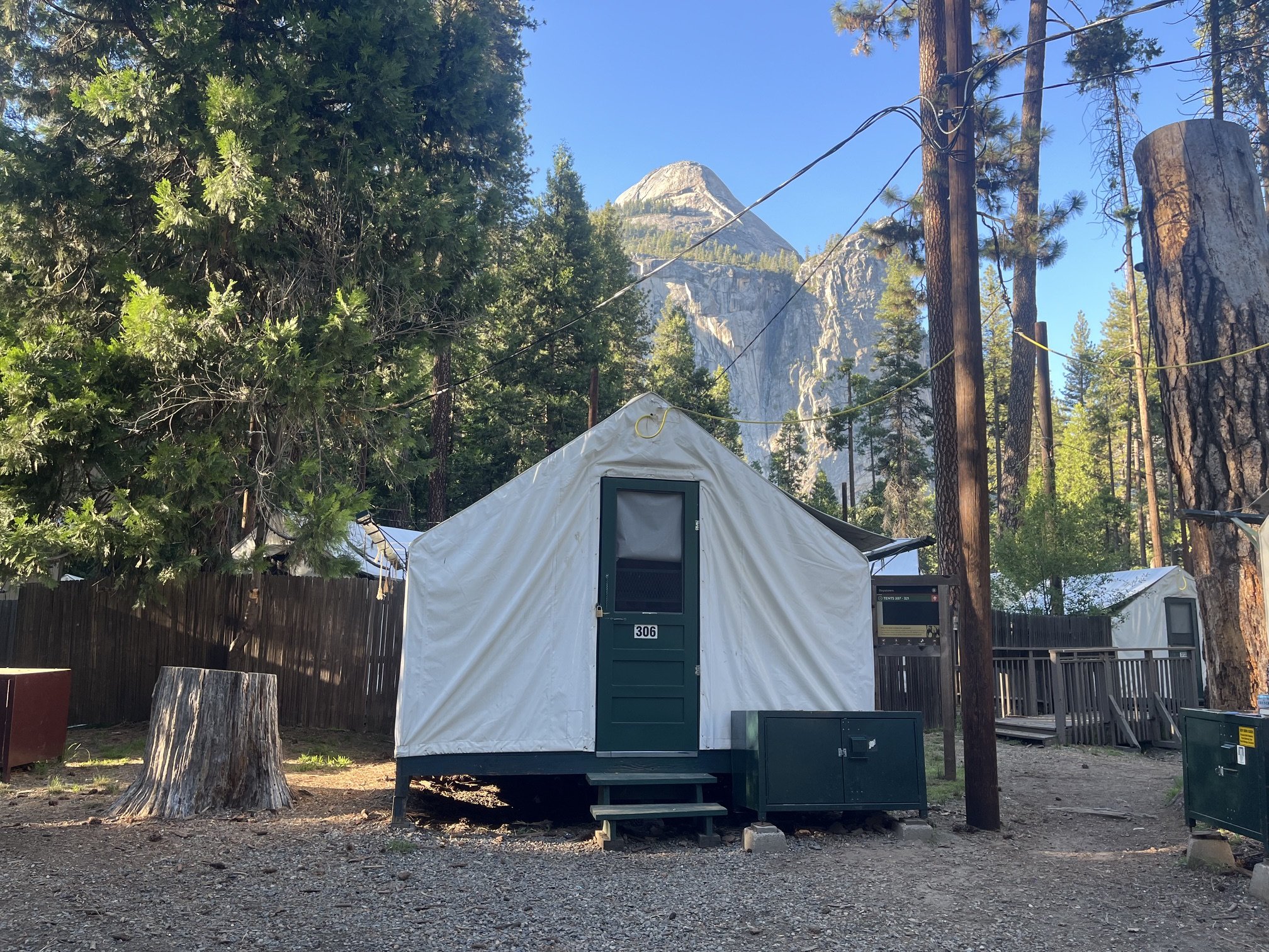 A canvas tent at Camp Curry in Yosemite National Park with towering granite cliffs in the background