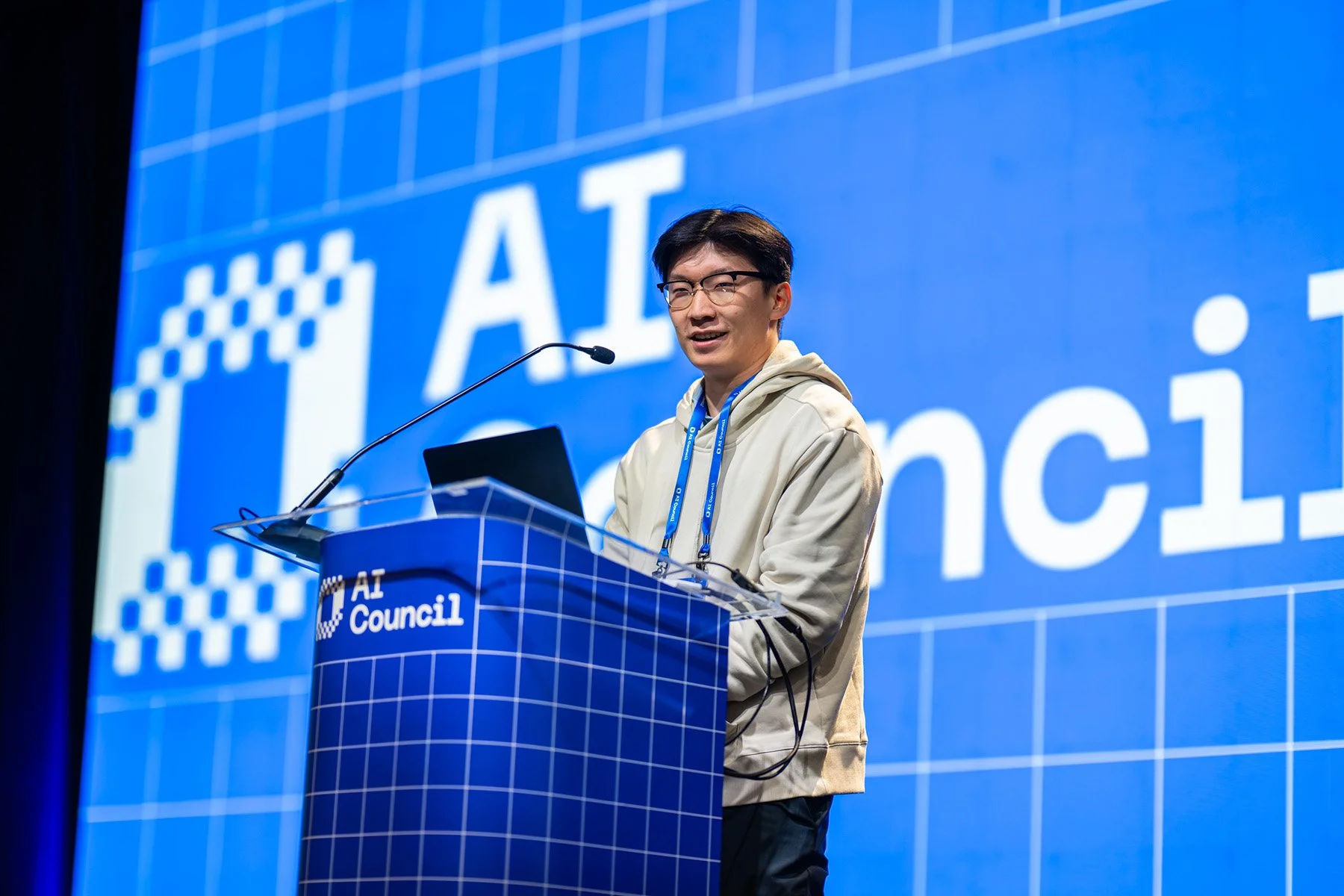 Speaker presenting from the stage during the AI Council conference.