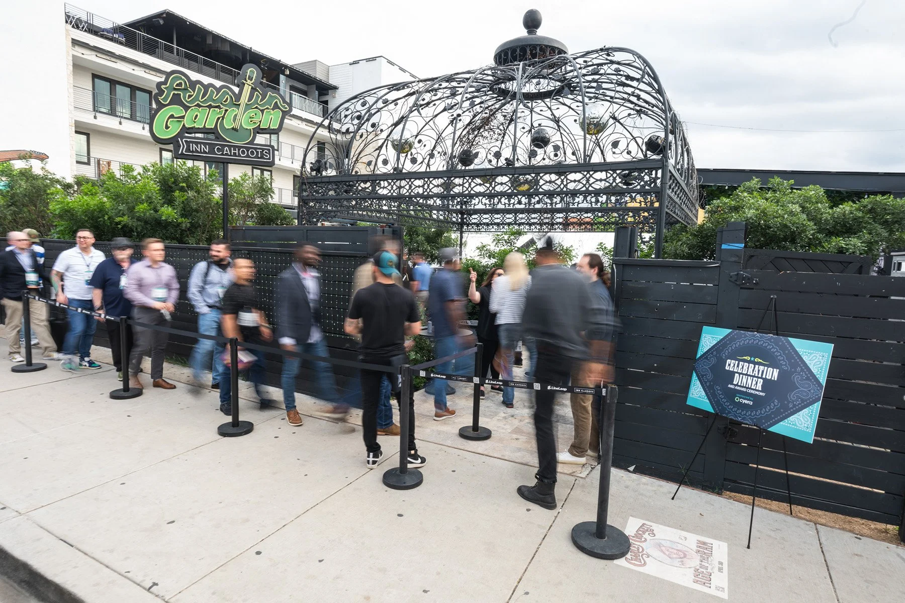 Austin event photography showing conference attendees arriving and lining up outside a venue entrance with custom event signage.