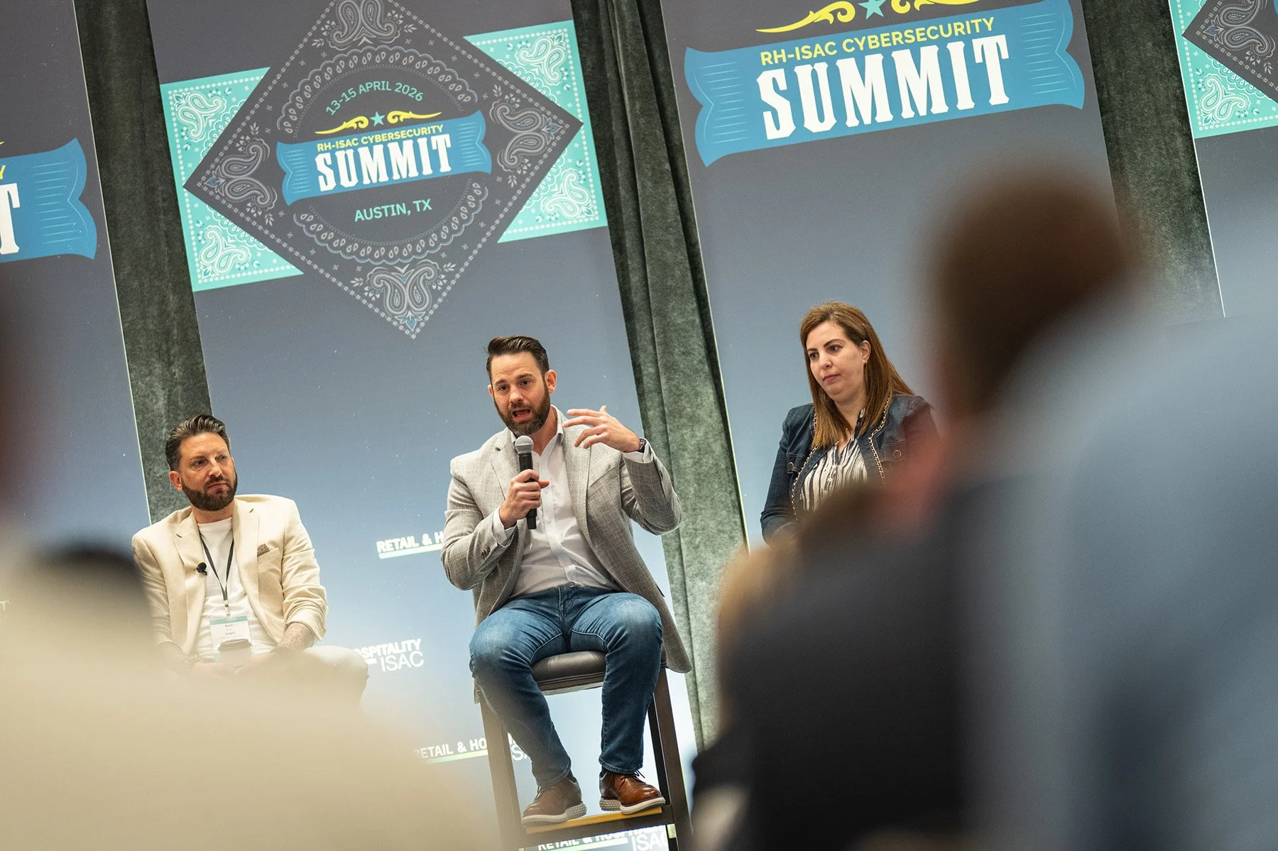 Austin conference photography showing an expert panel discussion with three speakers seated on stage at a corporate summit.
