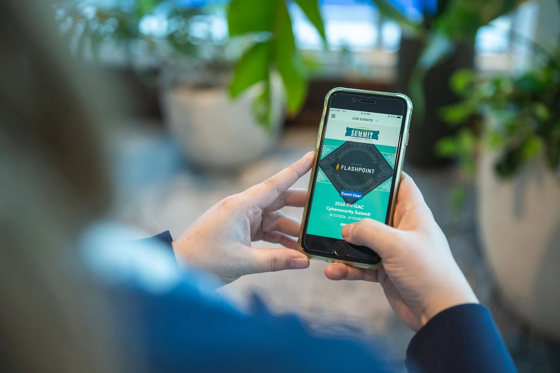 Detail shot of a person using a mobile app for the RH-ISAC Cybersecurity Summit 2024, representing event technology at an Austin conference.