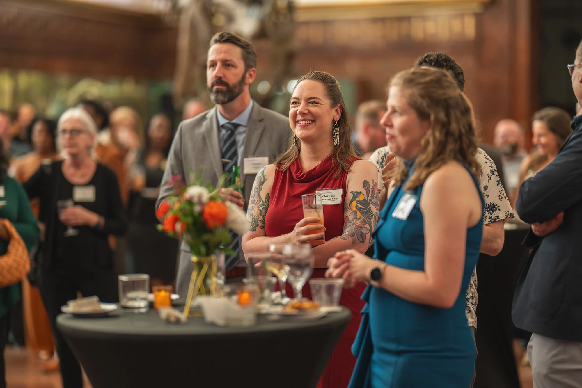 Candid Austin event photography showing guests smiling and networking around a cocktail table at a corporate conference reception