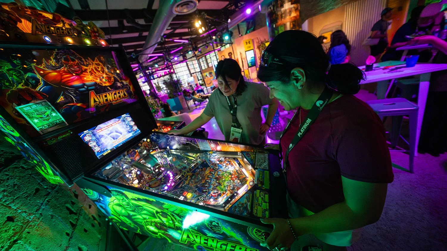 Attendees playing at a pinball table