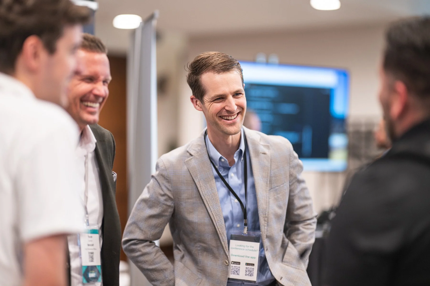 Austin corporate event photography of attendees in business casual laughing and networking at a conference expo.
