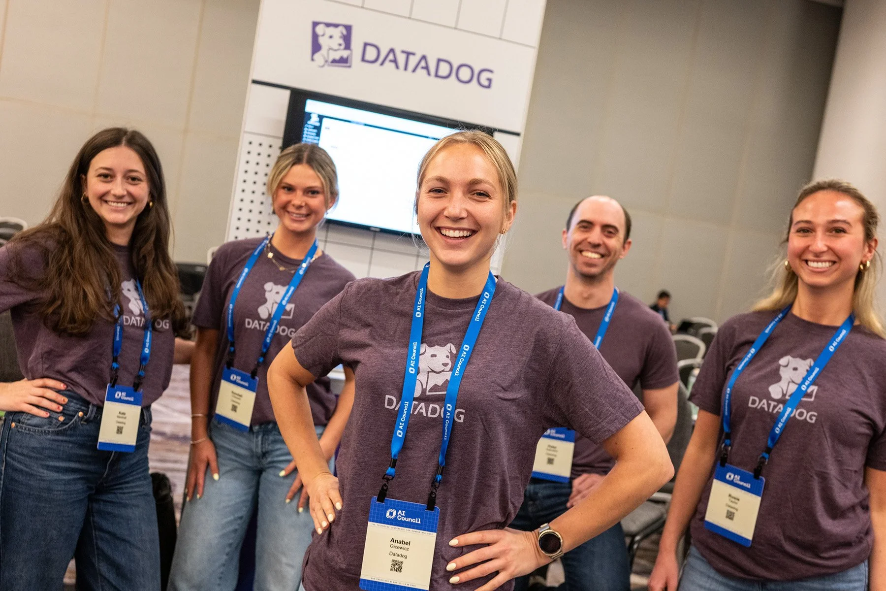 AI Council conference attendees posing for a group photo at a sponsor booth.