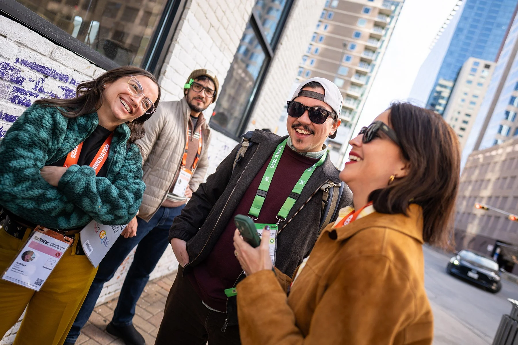 SXSW 2026 attendee joy in downtown Austin, Texas. Candid street portrait of diverse professionals with official conference badges. Authentic network connection at the festival. Professional event photography asset for brand promotion by Tico Mendoza