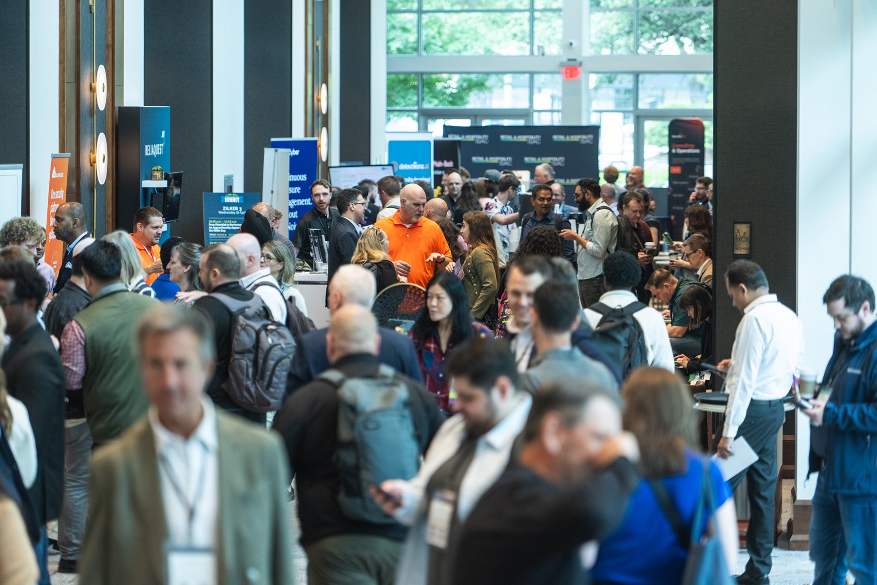 Wide-angle corporate event photo showing a crowded and active trade show expo floor with attendees exploring booths in an Austin venue.