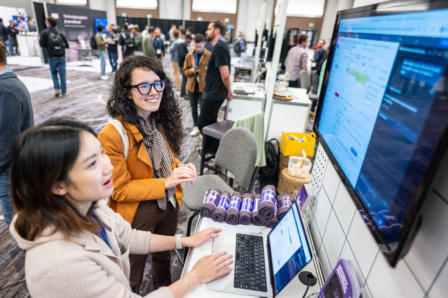 Exhibitor demonstrating AI software to an attendee during the AI Council conference expo.