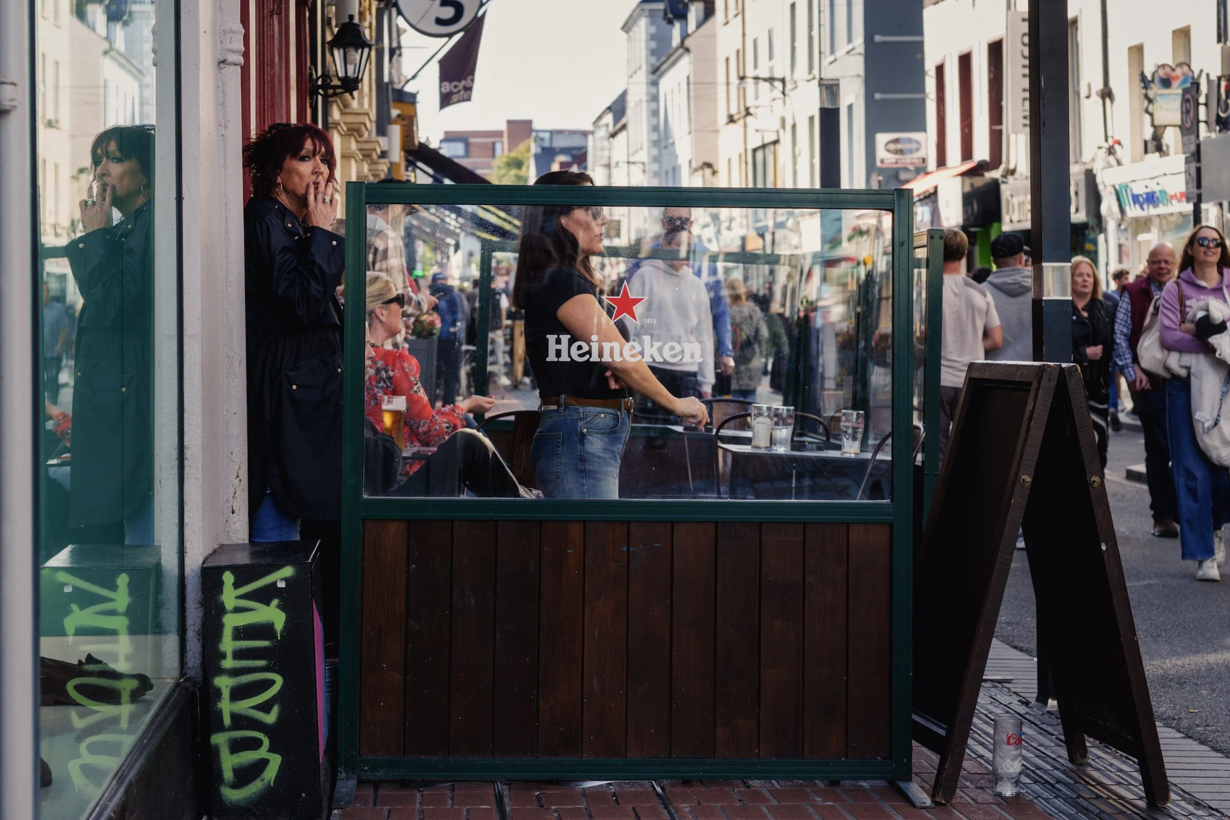 Two women outside a pub in Cork City Centre having a smoke, Cork City, Ireland, 2026 photographed by Dave Haworth