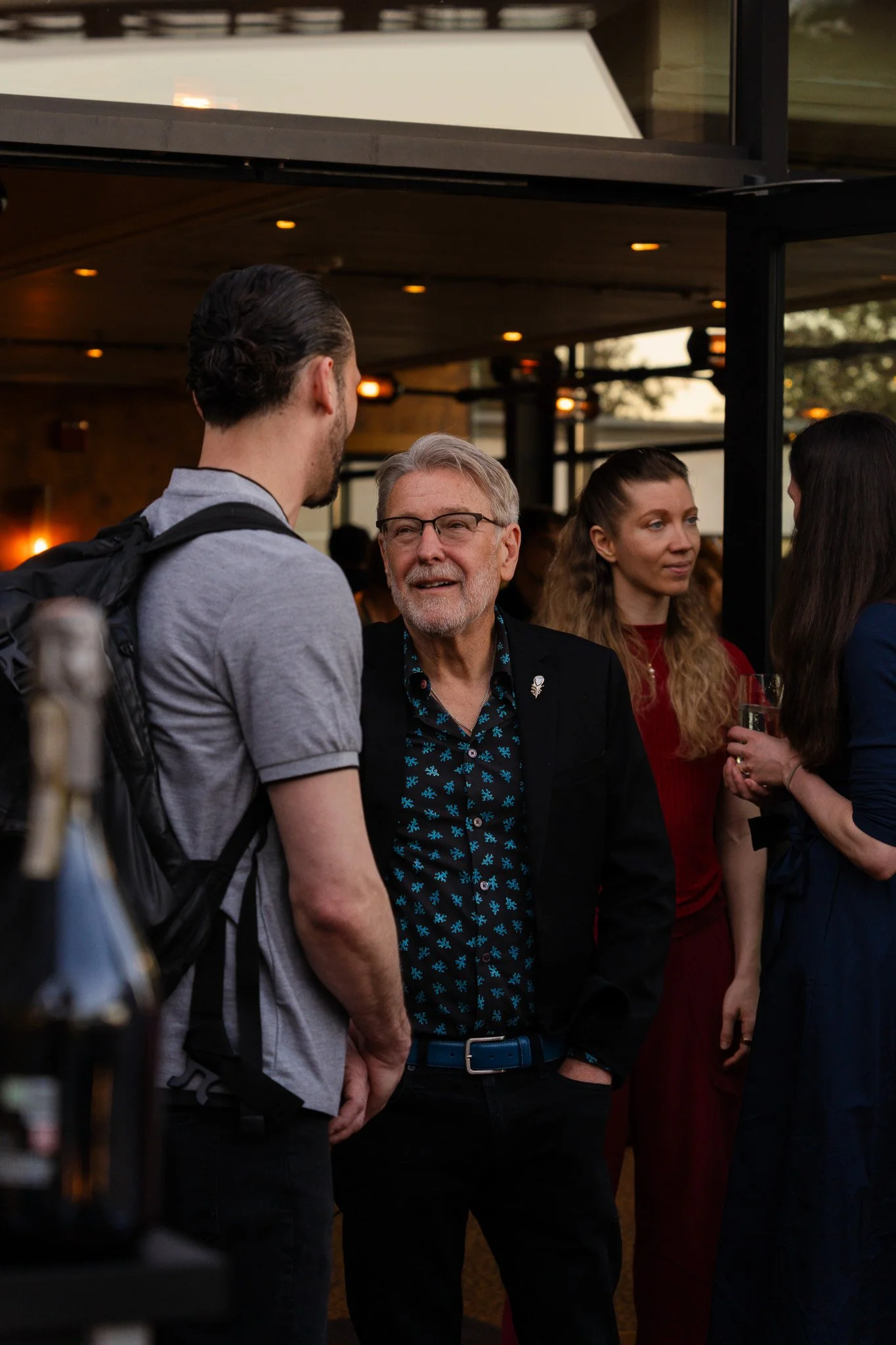 People engaging in conversation at a social gathering for the community, specifically an outdoor party taking place in San Francisco.