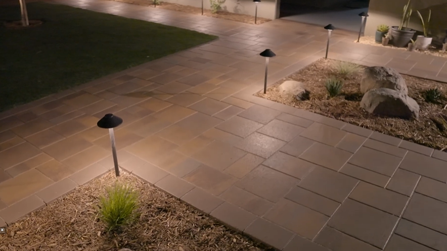 Beautiful paver walkway lit up with professionally installed landscape lighting