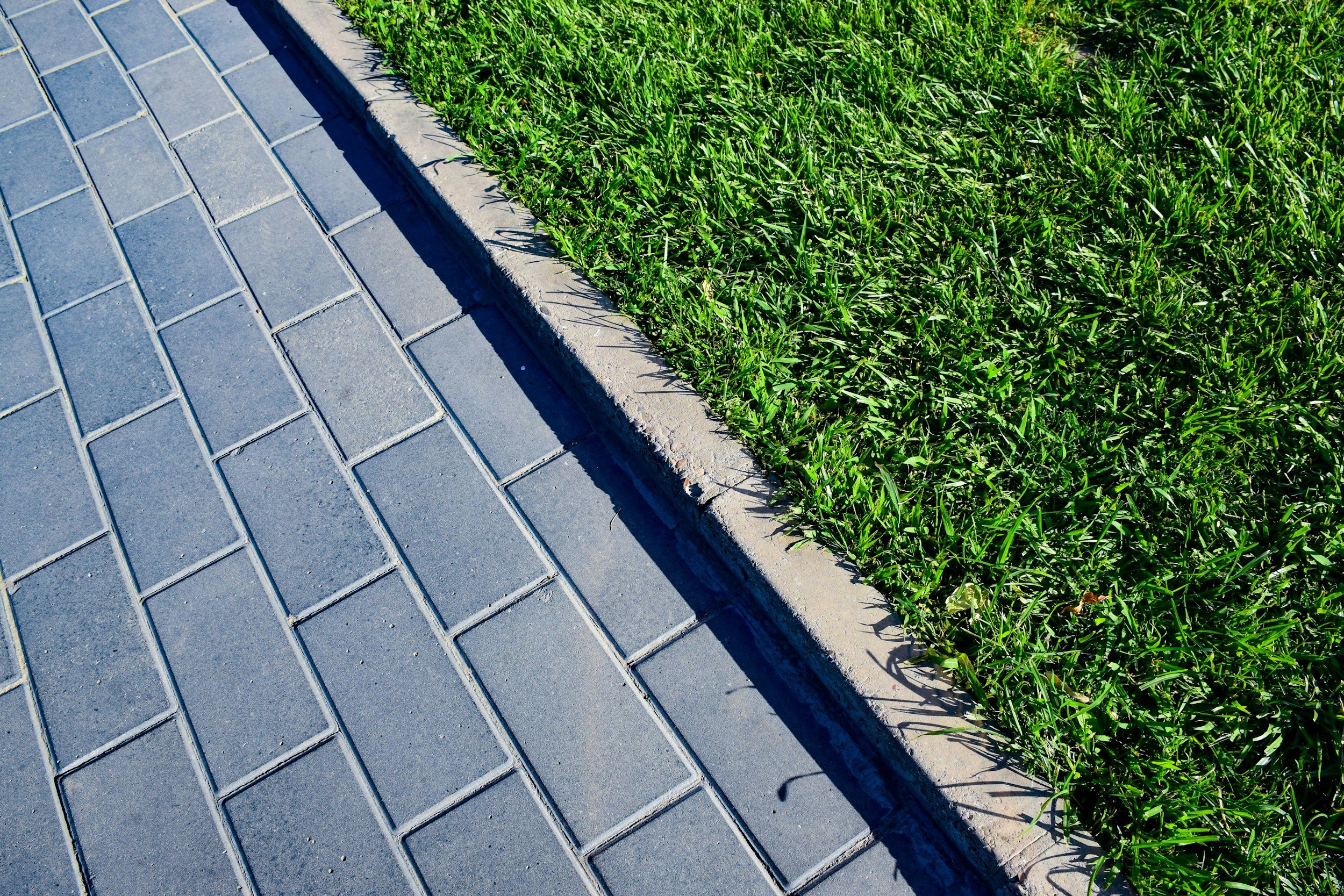 close up of clean paver walkway and green grass border