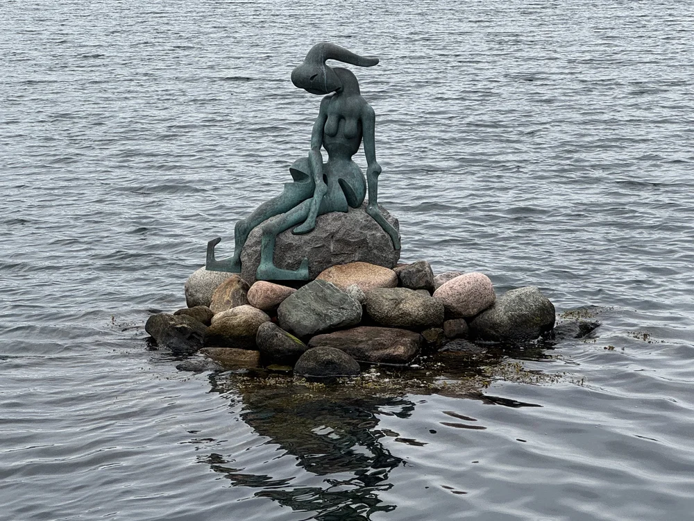  The Genetically Modified Little Mermaid near the old warehouses in the Copenhagen Harbour.  