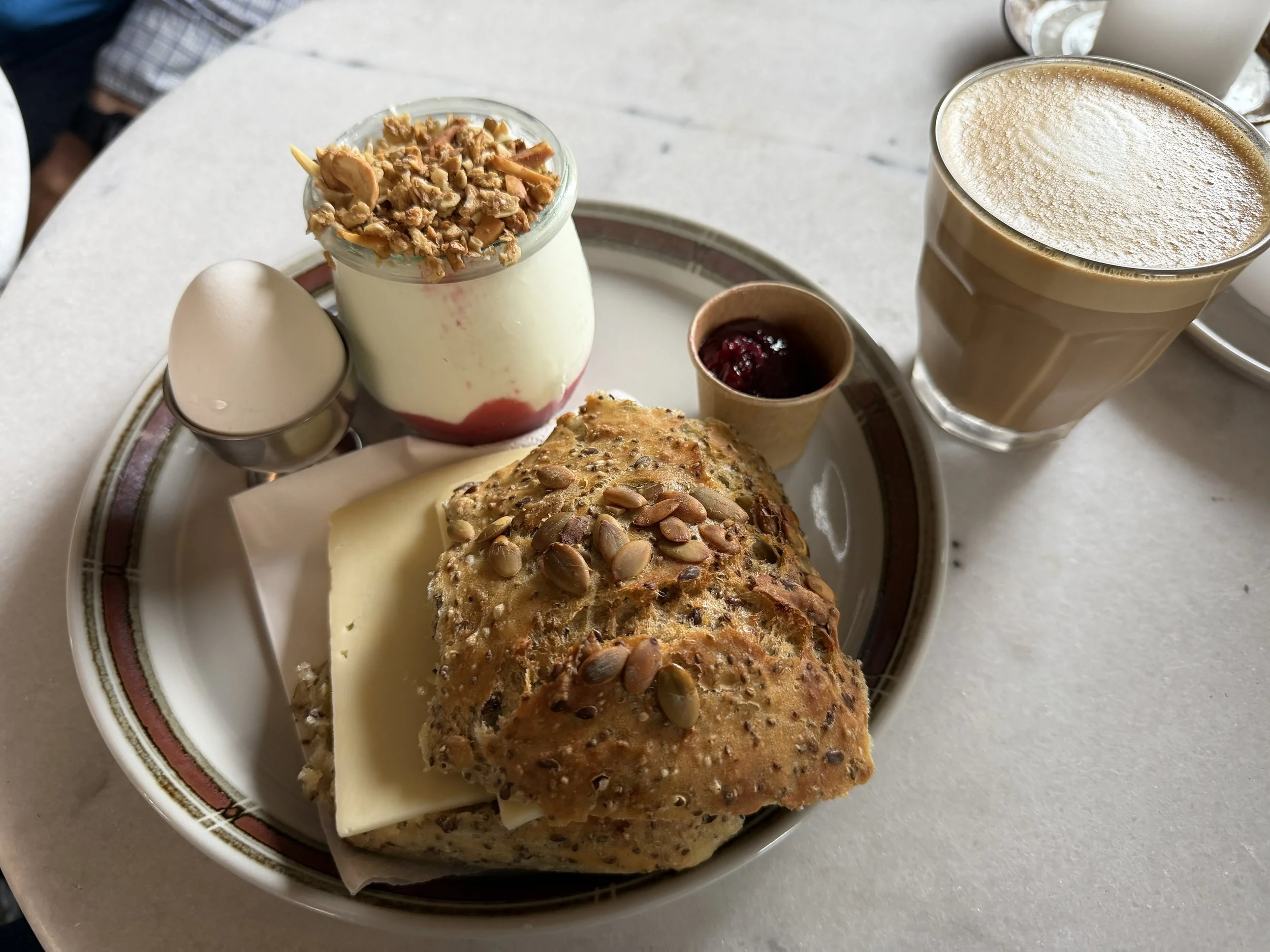   Standard Danish breakfast; crusty roll with cheese, soft boiled egg and a side of yogurt.  