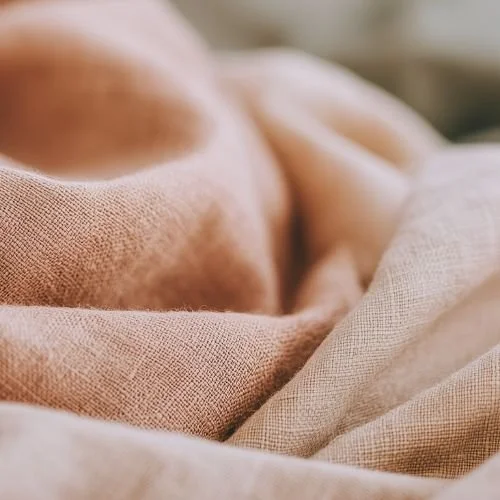 Close-up of soft, light-colored fabric or bedding.