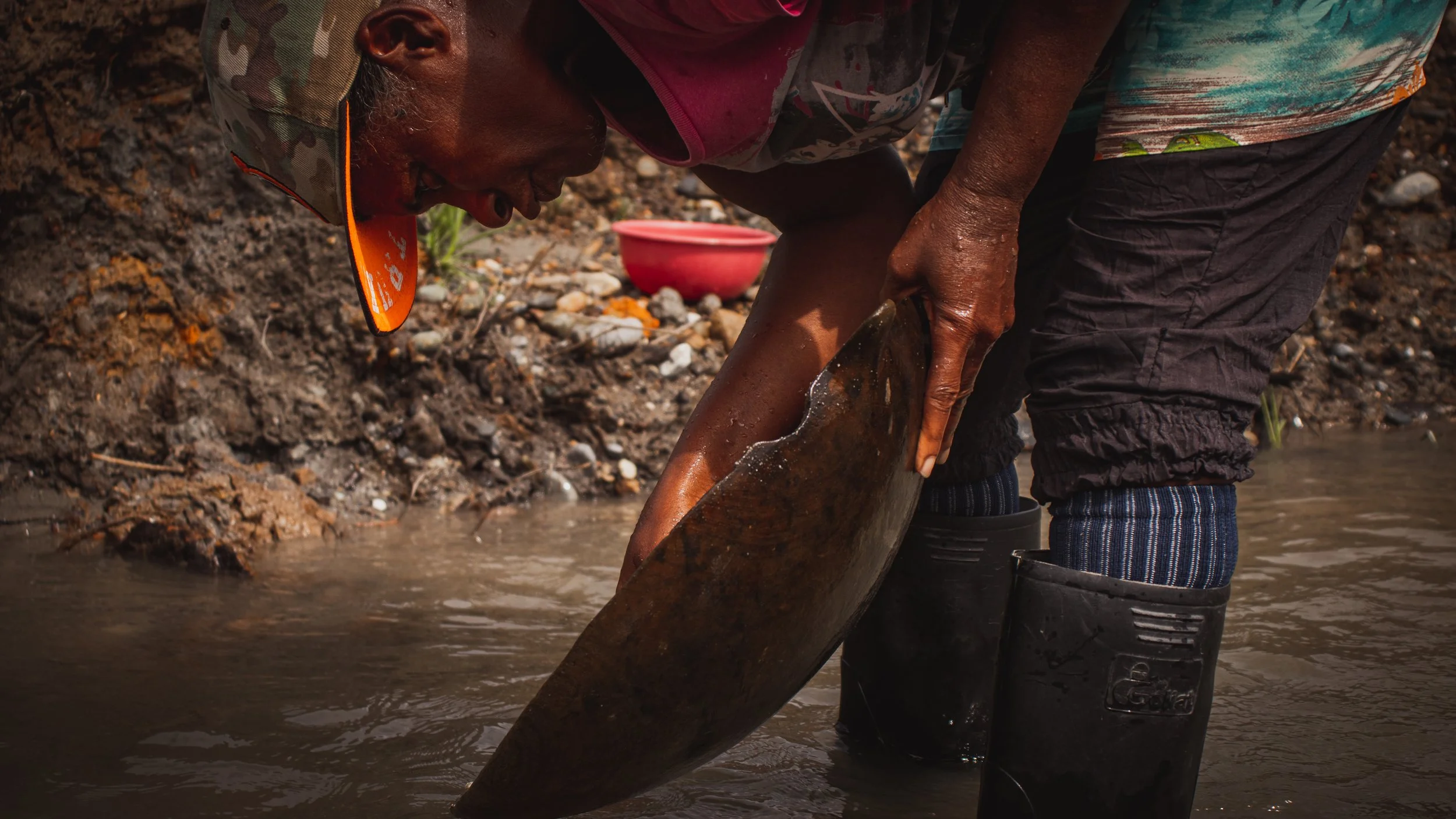 An woman artisanal miner pans for alluvial gold in Colombia.