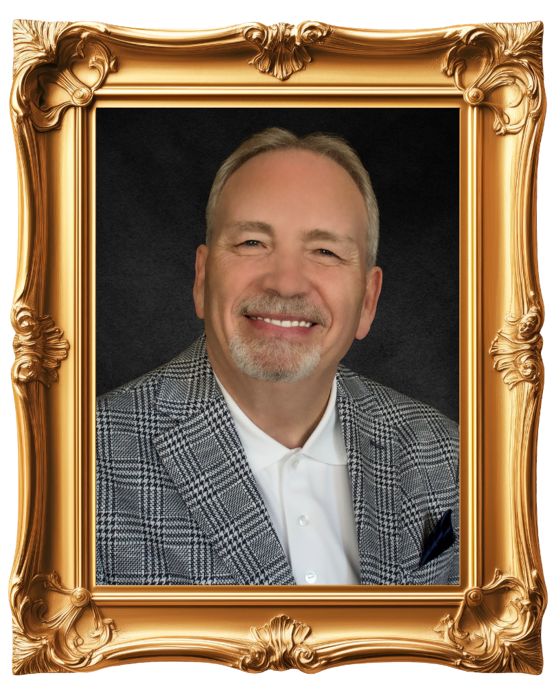 Founder Dr. Ray Vinson, with a mustache and goatee, smiling at the camera, wearing a checkered blazer and white polo shirt, framed in an ornate gold picture frame.